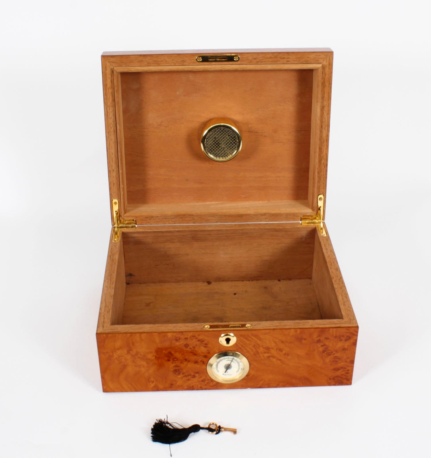 An elegant Vintage English Burr walnut humidor with fitted interior, mid 20th century in date.

The rectangular humidor features a burr walnut high gloss exterior with ebony edging, has a Spanish cedar-lined interior which helps to keep the aroma