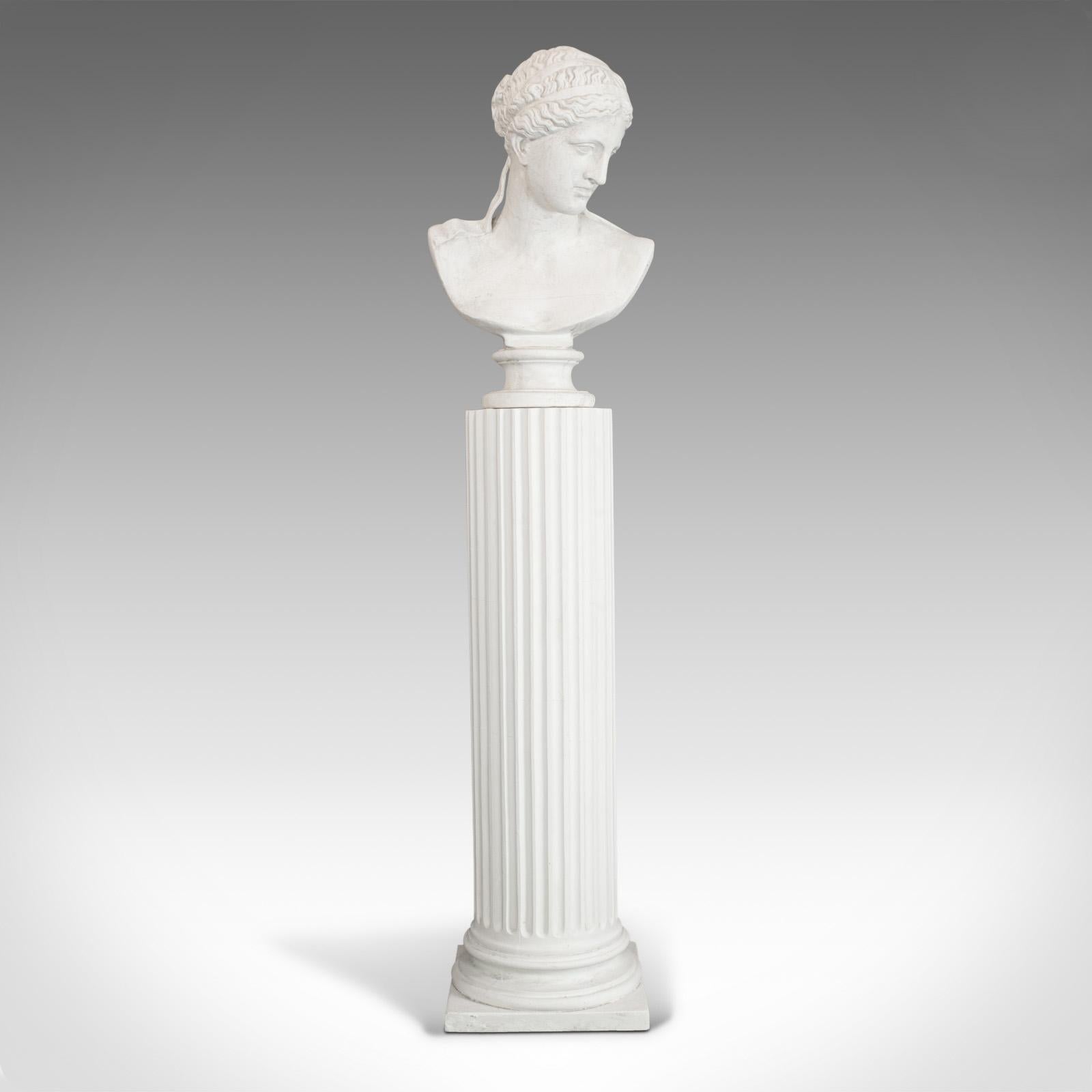 This is a vintage bust on pedestal. An English plaster cast female portrait atop a Doric column and dating to the late 20th century.

Classic Elegance and appealing form
Displays a desirable aged patina
Impressive proportion sure to enhance any