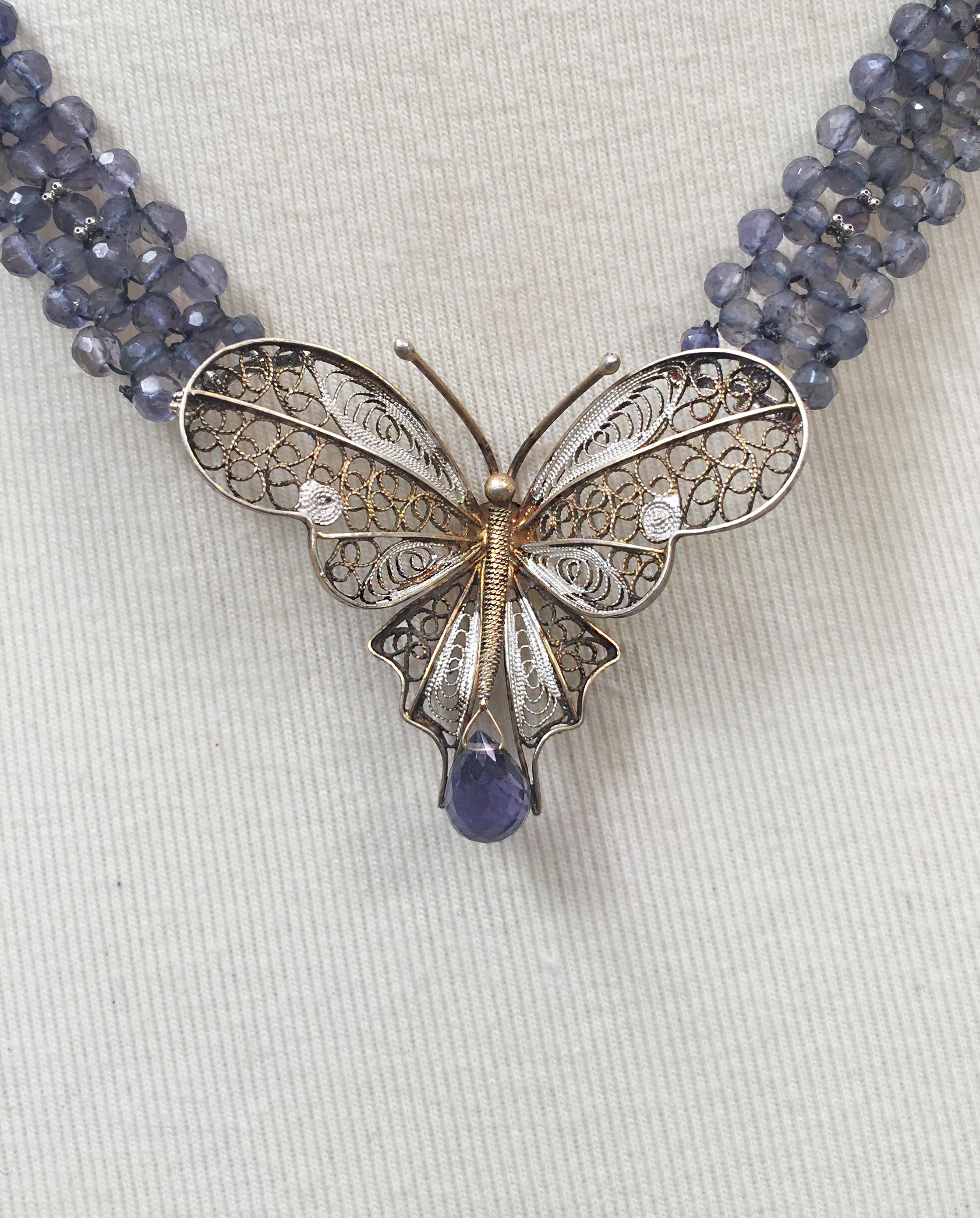 This intricate vintage butterfly brooch is attached to an iolite and 14 k white gold beaded necklace with a white gold clasp. The navy blue of the iolite faceted beads highlights the silver and gold of the vintage butterfly brooch. Shining in