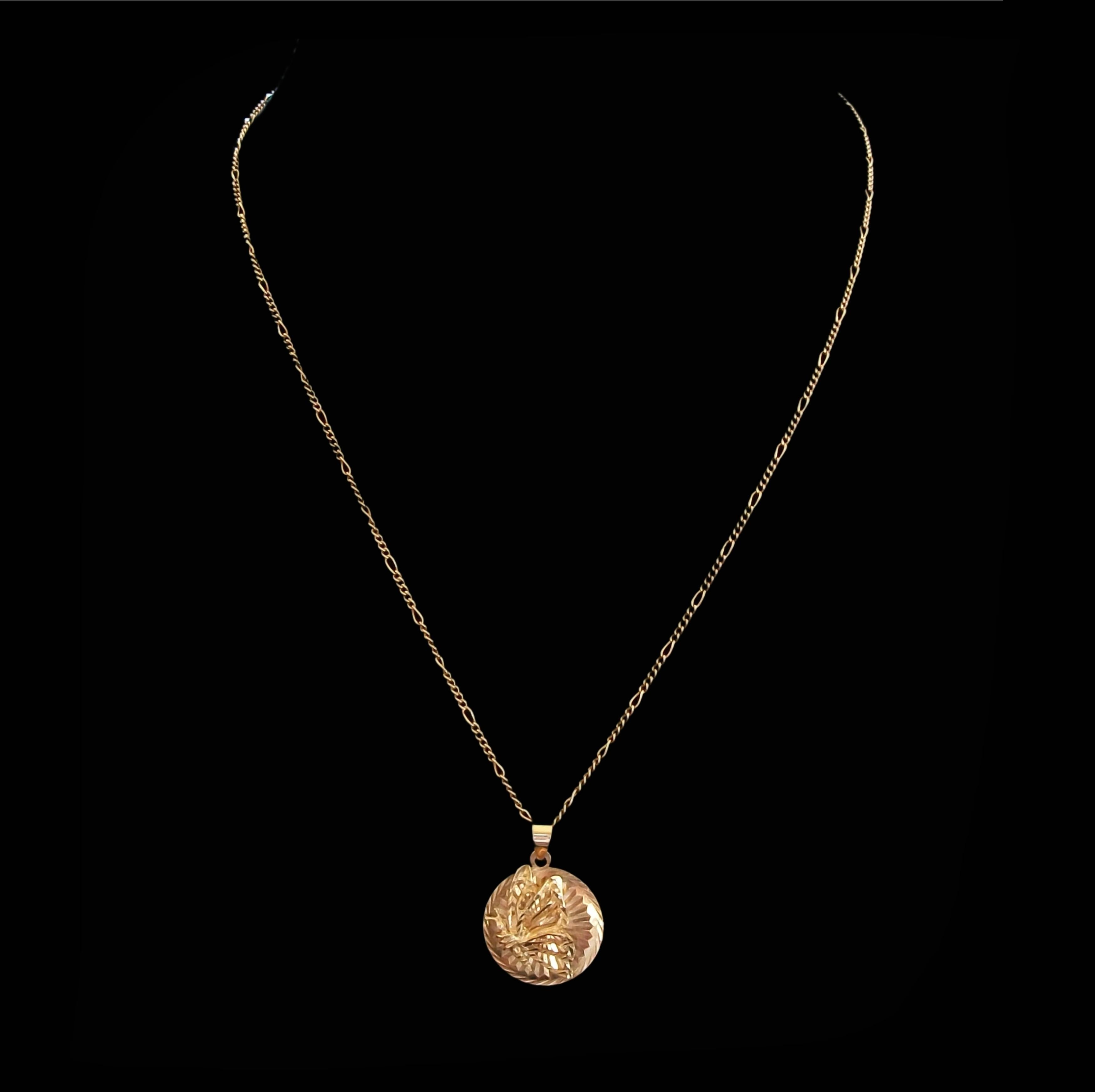 Ravissant collier pendentif papillon vintage - le pendentif en or jaune 10K représente un papillon en vol en trois dimensions serti sur un disque rond à motifs avec une grande attache - le pendentif est suspendu à une chaîne à maillons figaro en or