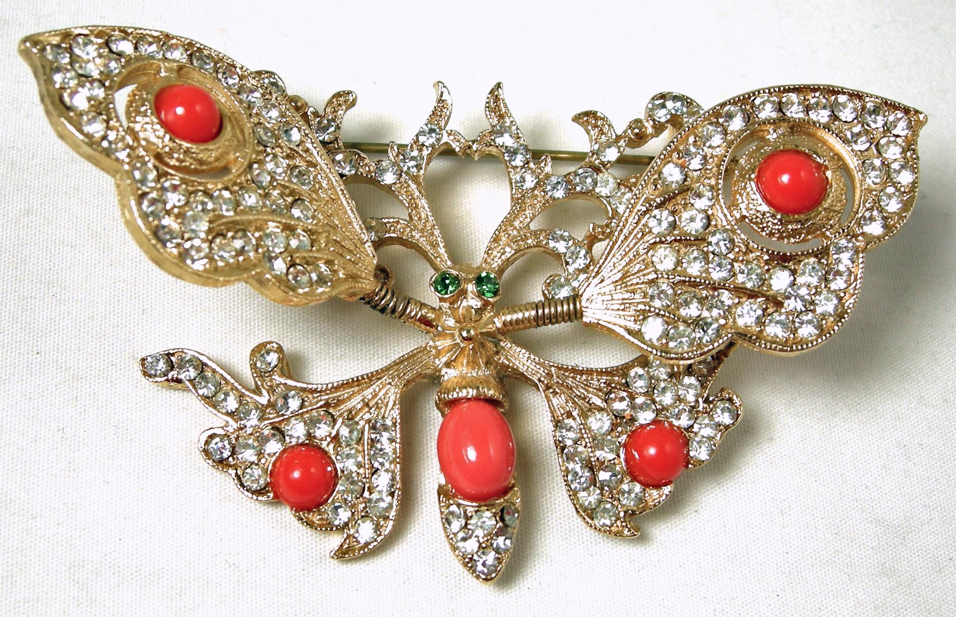 Here is a vintage trembler butterfly brooch with faux coral and clear crystals in a gold tone setting.  The wings move along with you.  In excellent condition, this brooch measures 2-7/8” x 1-5/8”.