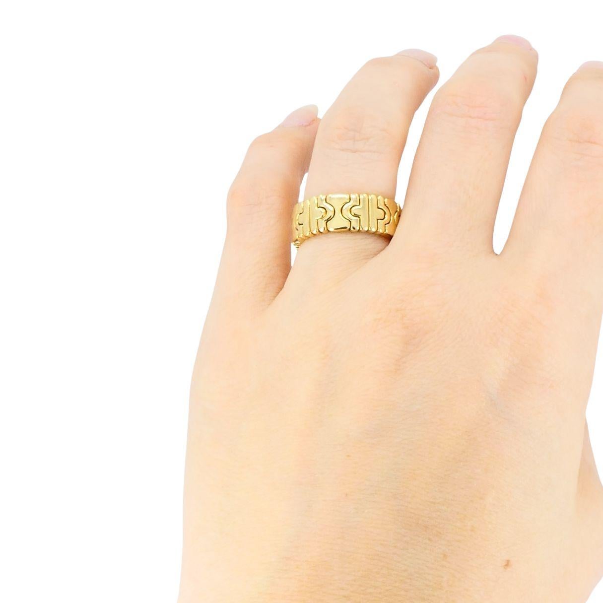 Questo anello vintage Bvlgari Parentesi è un raffinato esempio dell'artigianato italiano e dell'audace design architettonico del marchio. Realizzato in oro giallo 18 carati su un cinturino in acciaio lucido, ogni segmento d'oro si muove sottilmente