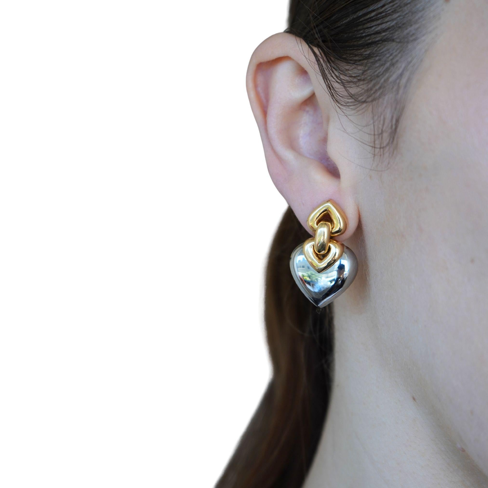 Questo paio di orecchini vintage Bvlgari dell'iconica collezione Doppio Cuore, realizzata negli anni '90. Questi orecchini in acciaio e giallo 18 carati presentano il caratteristico motivo a due cuori, uno in caldo oro giallo e l'altro in acciaio