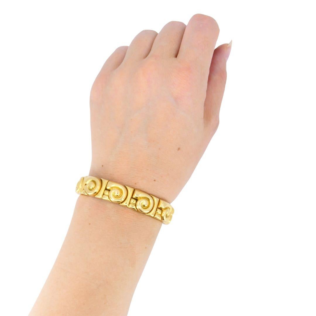 Questo bracciale vintage di Bulgari unisce il lusso alla forza. Le maglie esterne presentano un motivo a spirale ripetuto in oro giallo 18 carati, mentre la struttura interna è realizzata in acciaio inossidabile, un segno distintivo dell'uso