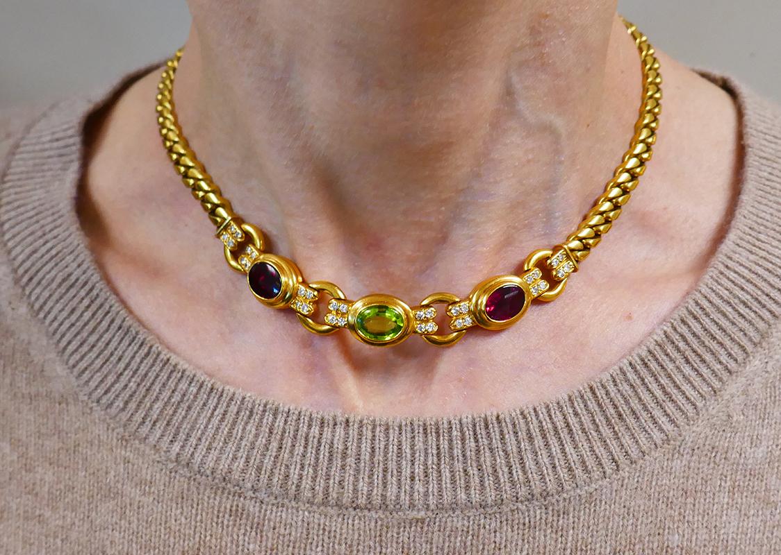 Elegant and stylish chain necklace created by Bulgari in Italy in the 1970s. 
Made of 18 karat yellow gold, the necklace features two oval faceted rubelites and a peridot accented with round brilliant cut diamonds (F-G color, VS1 clarity, 0.64 carat