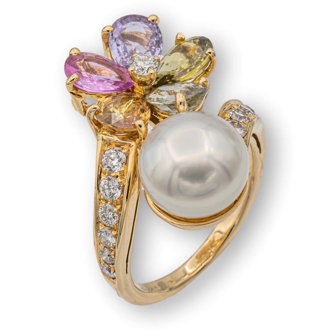 Vintage Bvlgari bypass ring from the Contraire collection finely crafted in 18 karat yellow gold featuring a flower motif adorned with pear shape multicolor sapphires weighing 0.50 carats each approximately and a 10 mm south sea pearl. The ring has