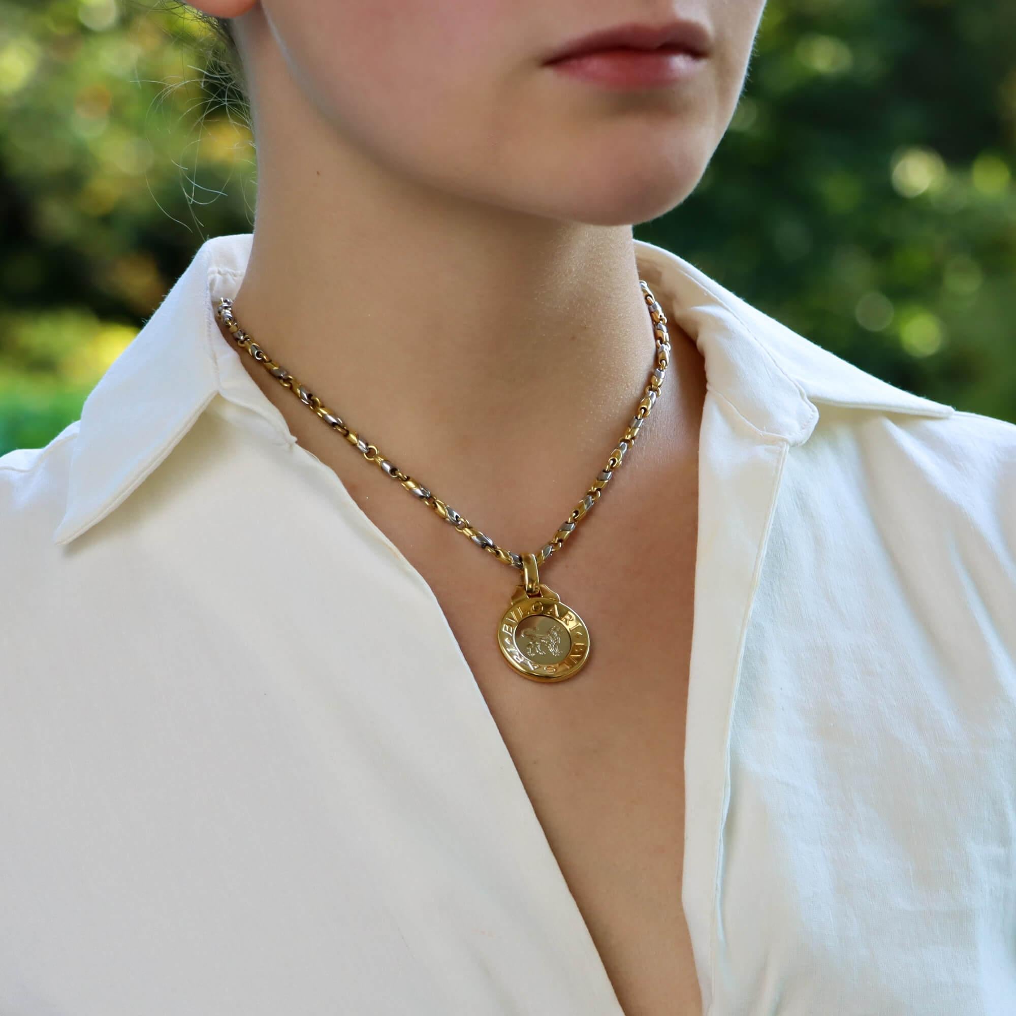 A stylish vintage Bvlgari Zodiac pendant and matching chain set in 18k yellow gold and stainless steel. 

The piece is firstly composed of a circular medallion which is set to the centre with stainless steel panel. Engraved in the stainless steel is
