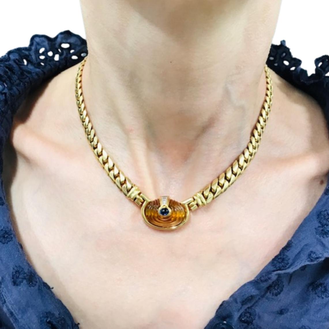 Ce collier vintage Bulgari est réalisé en or jaune 18 carats et met en valeur le style audacieux et raffiné de la marque. 
Au centre se trouve un cabochon de citrine sculpté d'une chaude teinte dorée, enchâssé dans une lunette en or lisse. Au-dessus