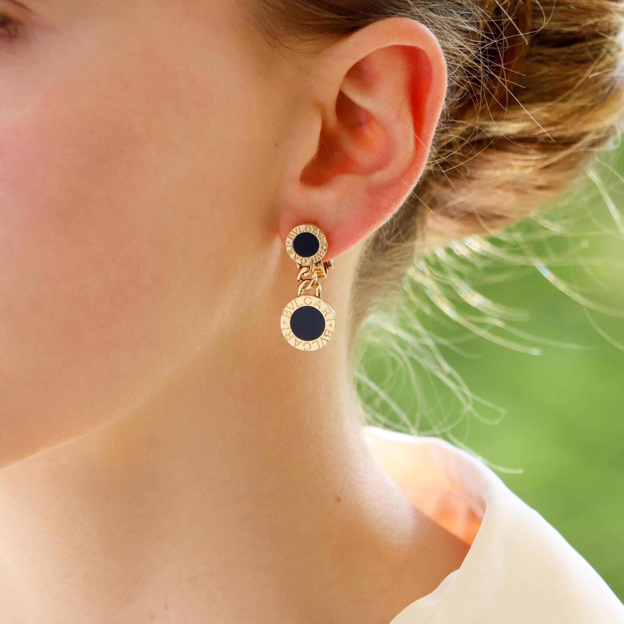  A beautiful vintage pair of Bvlgari onyx earrings set in 18k yellow gold.

From the 'Bvlgari Bvlgari' collection, each earring is composed of a yellow gold and onyx disc, engraved in the border with the brands logo. Hanging from this disc is a flat