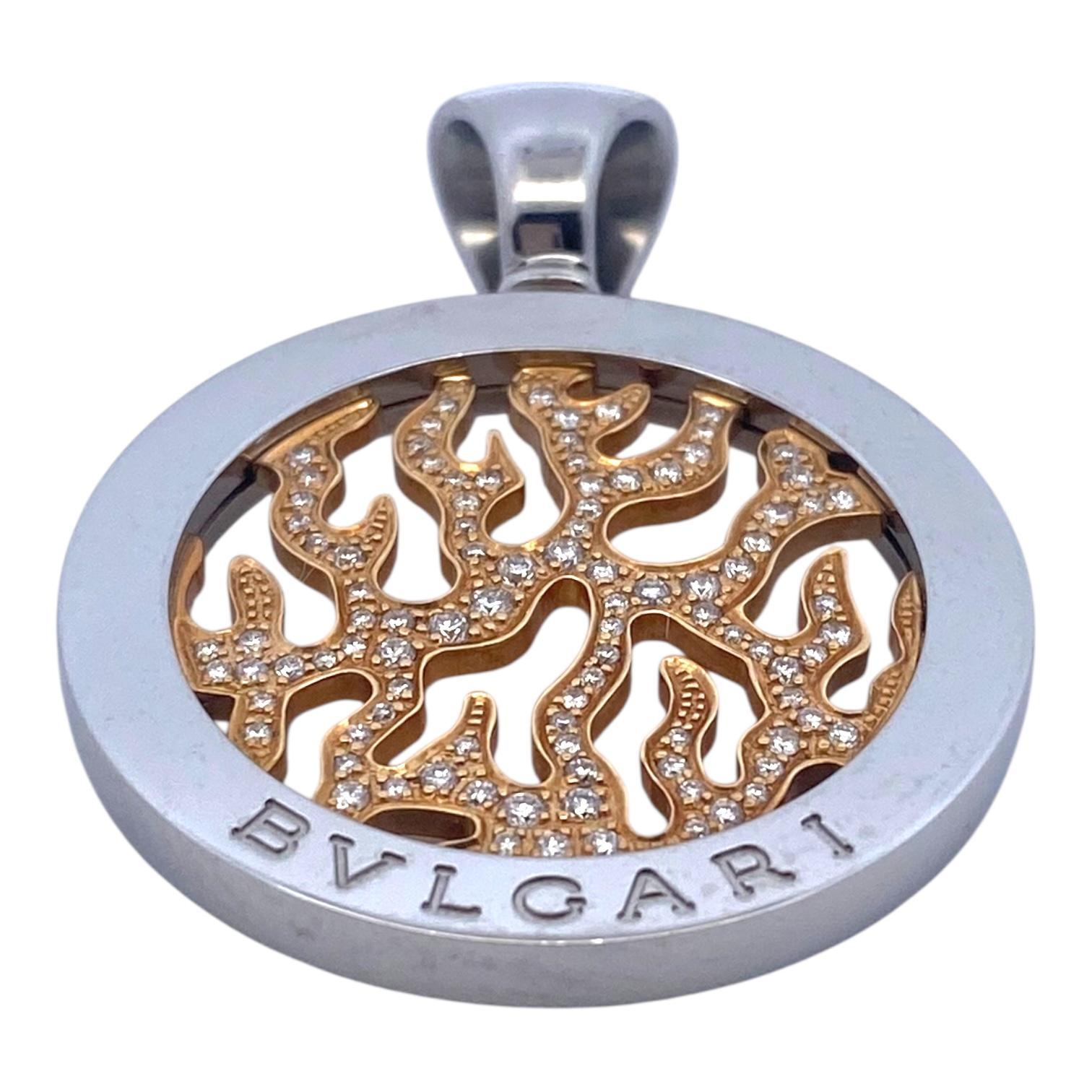 Vintage Bulgari Tondo Fire Anhänger mit einem Flammenmotiv aus Gelbgold in der Mitte, besetzt mit runden Diamanten im Brillantschliff, umrahmt von einer großen Edelstahllünette mit übergroßem Bügel.
Diamanten: 0,65ctw. Farbe: F-G, Reinheit: