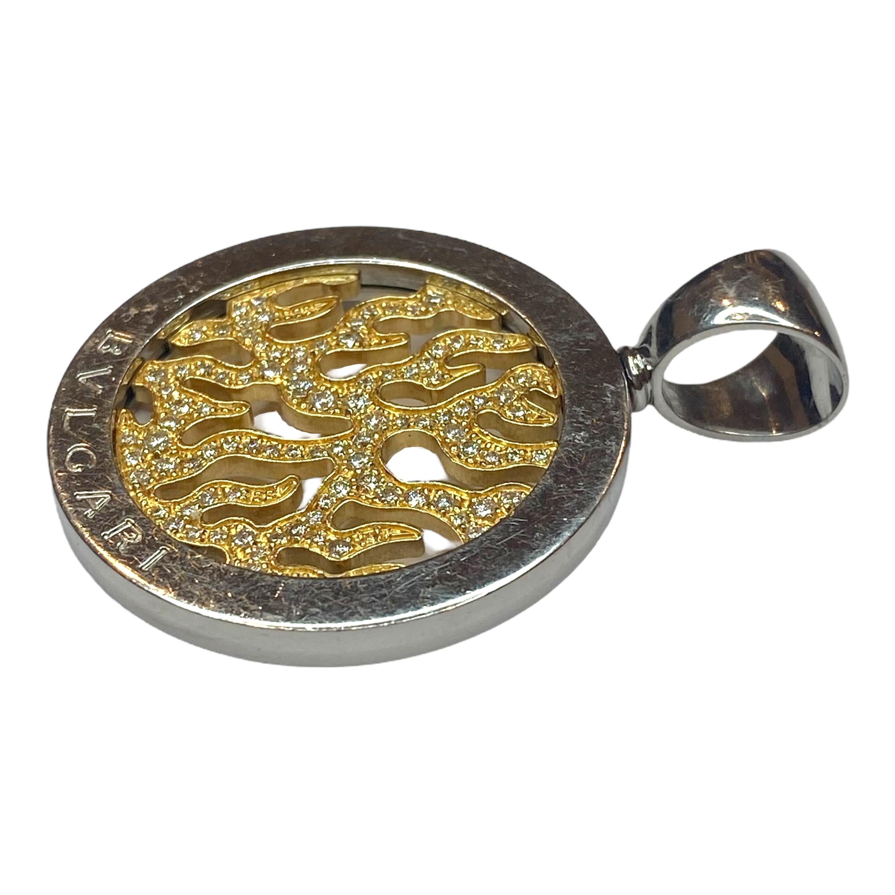 Vintage BVLGARI Tondo Fire Anhänger mit einem Flammenmotiv aus Gelbgold, das in der Mitte mit runden Diamanten im Brillantschliff besetzt ist, umrahmt von einer großen Edelstahllünette mit übergroßem Bügel.
Diamanten: 0,65ctw. Farbe: F-G, Reinheit:
