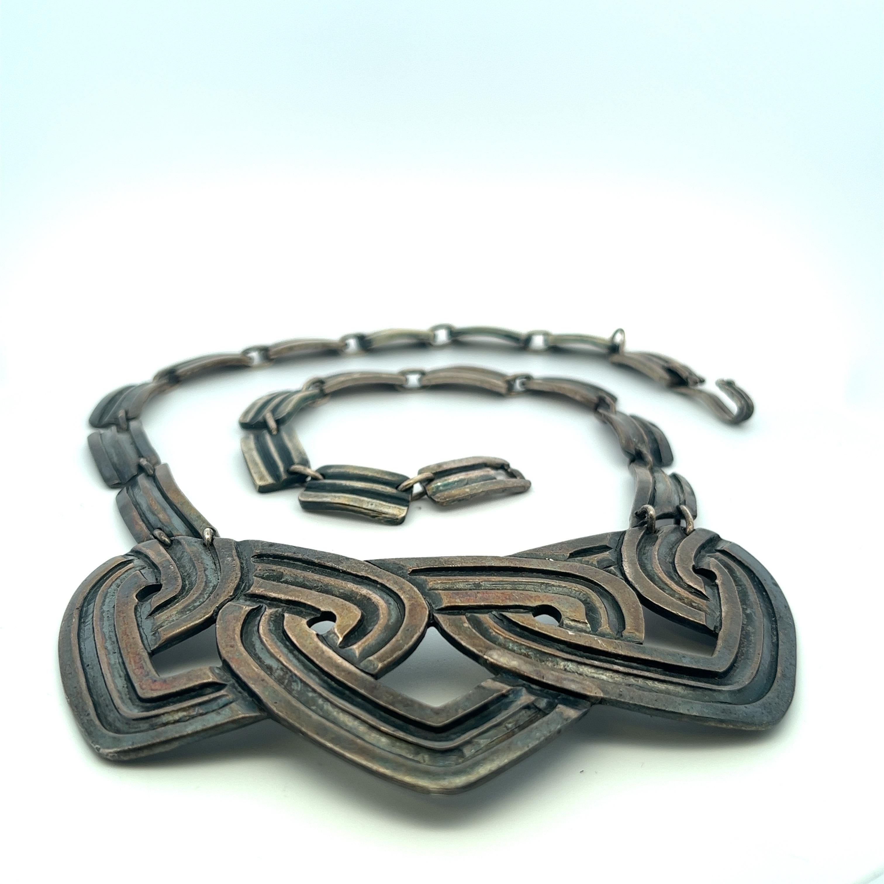 Introducing a rare and exceptional Los Castillo necklace featuring a beautiful and natural patina.  Dating back to the 1940s in Taxco, Mexico, this vintage piece showcases a distinctive choker-style design, draping gracefully on the chest with an