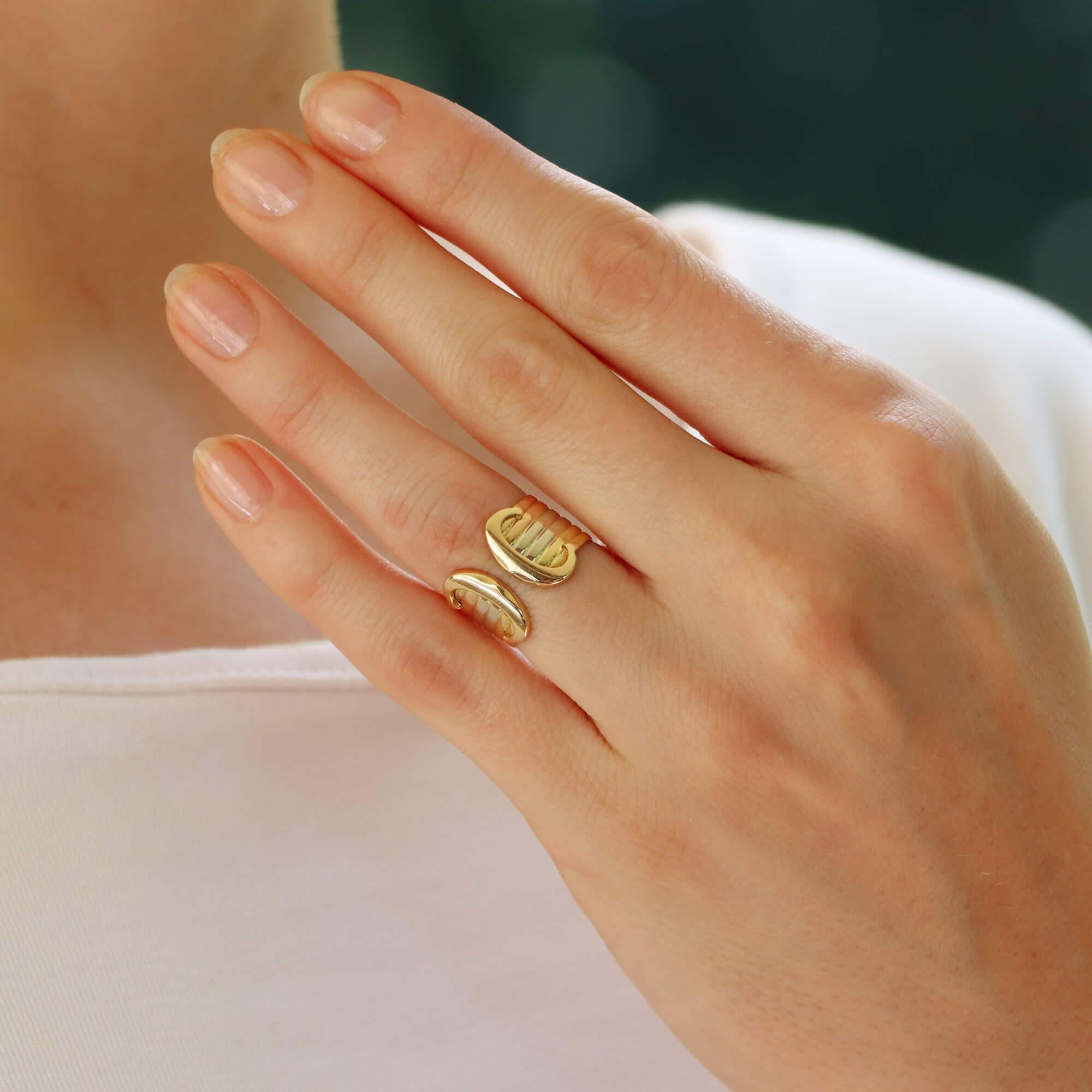 A classic vintage C de Cartier open band ring set in 18k rose, white and yellow gold.

The piece is from one of the iconic Cartier collections. The ring is made of six solid soldered tricoloured bands. These bands flow round nicely to the front of