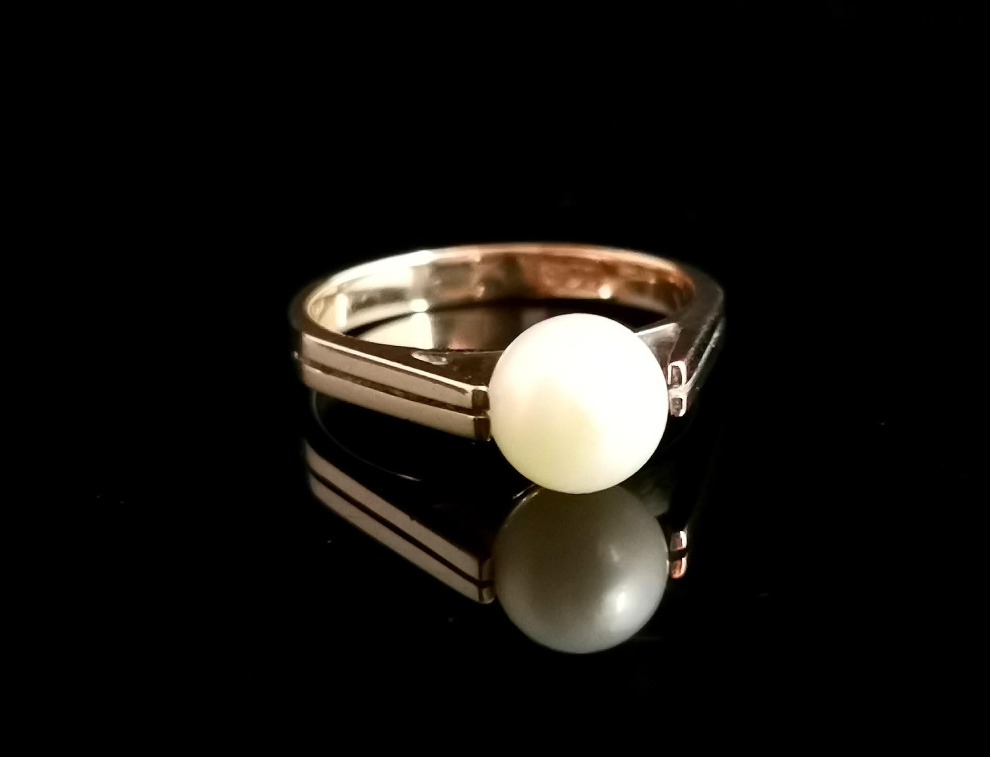 A gorgeous vintage 9 karat yellow gold pearl solitaire ring.

A mid century beauty, c1940s this ring has a nice substantial 9 karat gold band with geometric upswept shoulders that hug a single creamy cultured pearl.

The angular lines of the