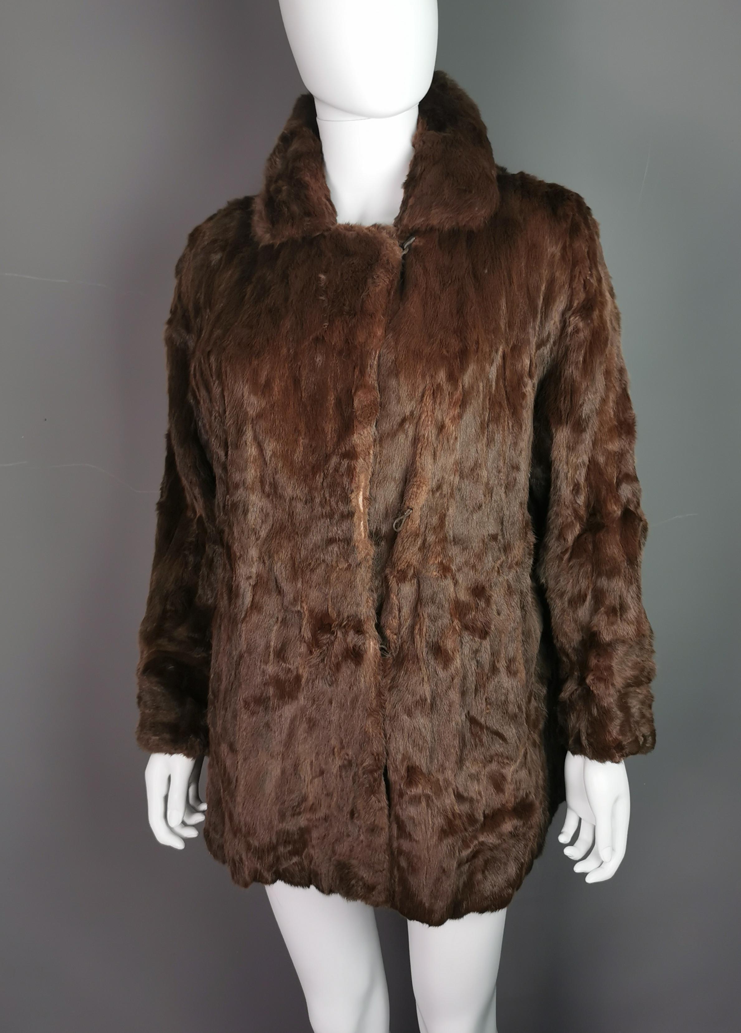 A fine quality vintage mink fur jacket by Clyne.

It is made from mahogany brown mink fur, superbly soft and lined in a chocolate brown satin.

It has a nice wide collar with a half belt design to the back.

It hook fastenings to the front and is