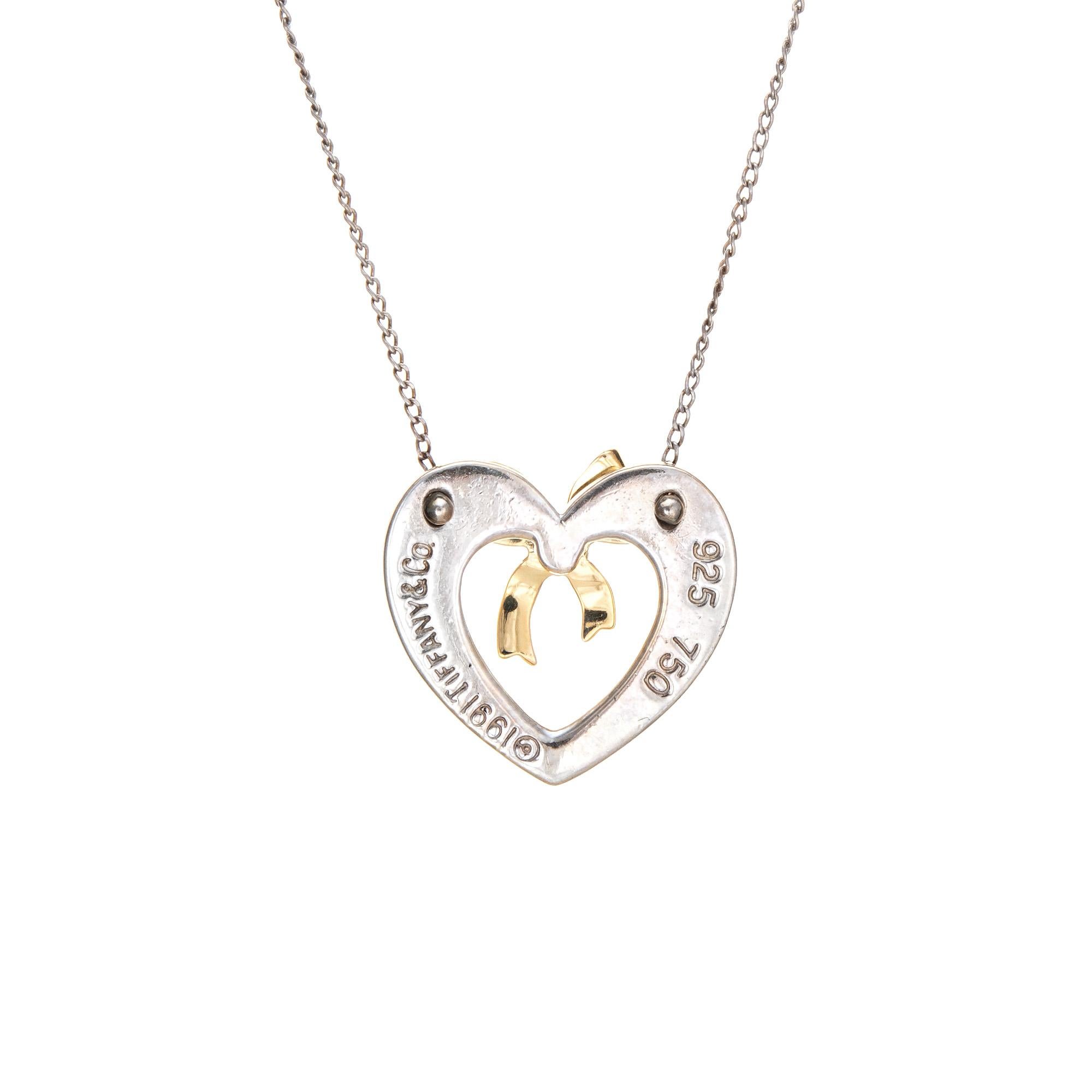 Stylish and finely detailed vintage Tiffany & Co heart & bow necklace, crafted in sterling silver and 18k yellow gold (circa 1991).  

The sweet heart shaped necklace features a bow to the center in 18k yellow gold. Measuring 18 inches in length the