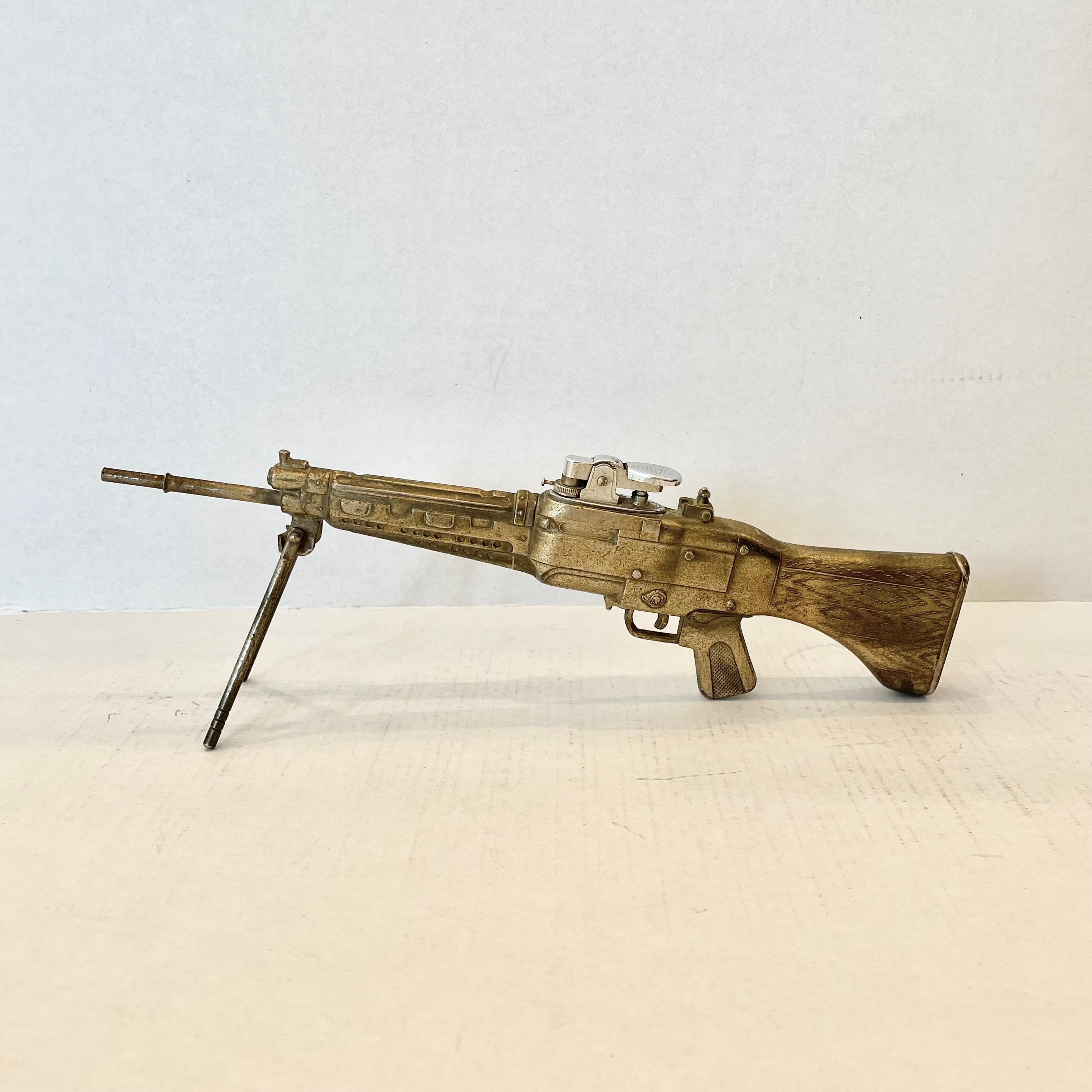 Cool vintage table lighter in the shape of a C6 machine gun. Made of metal and stands up on its own. Bipod arms fold up and down. Heavy patina giving this piece a unique color with silver and brown hues. Cool tobacco accessory and conversation