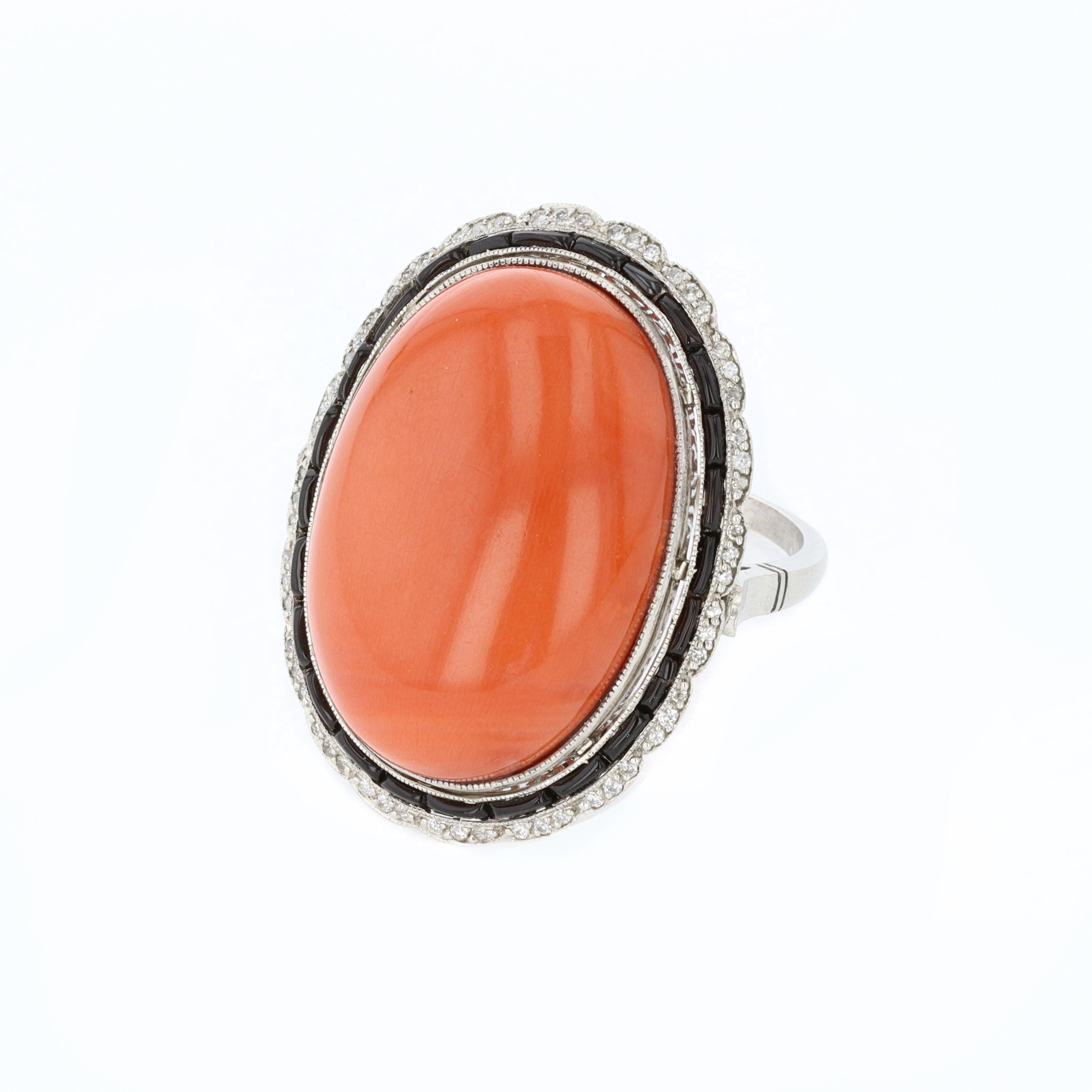 Ladies platinum cabachon coral and black onyx Art Deco cocktail ring. The center of the ring is a cabachon coral that is surrounded by calibre cut onyx and round cut diamonds. The weight of the diamonds is .25 ctw and the color and clarity is H VS.