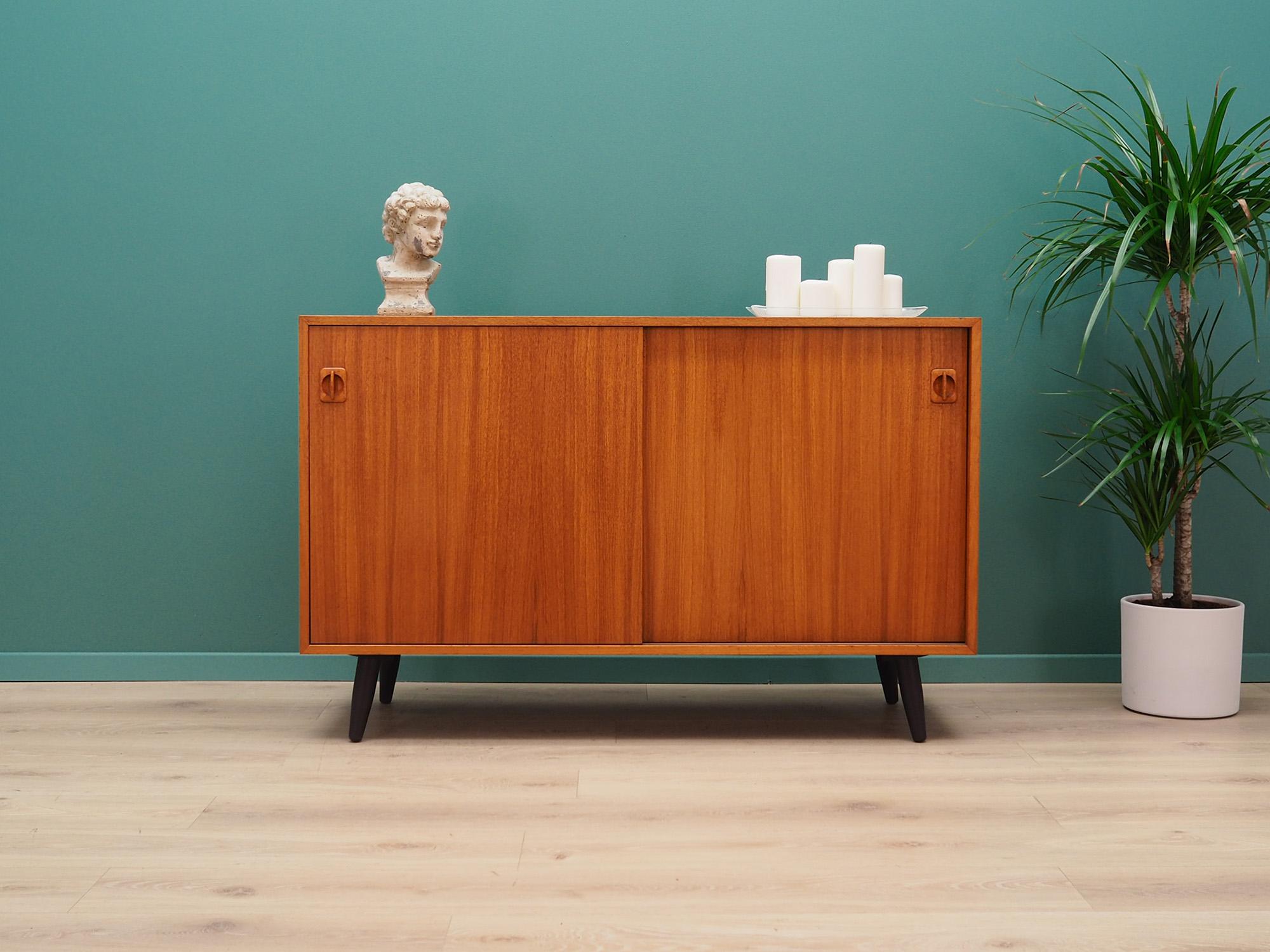 Fantastic cabinet from the 1960s-1970s. Scandinavian design, Minimalist form. Surface of the furniture finished with teak veneer. Cabinet has two shelves behind a sliding doors. Preserved in good condition (minor bruises and scratches, filled veneer