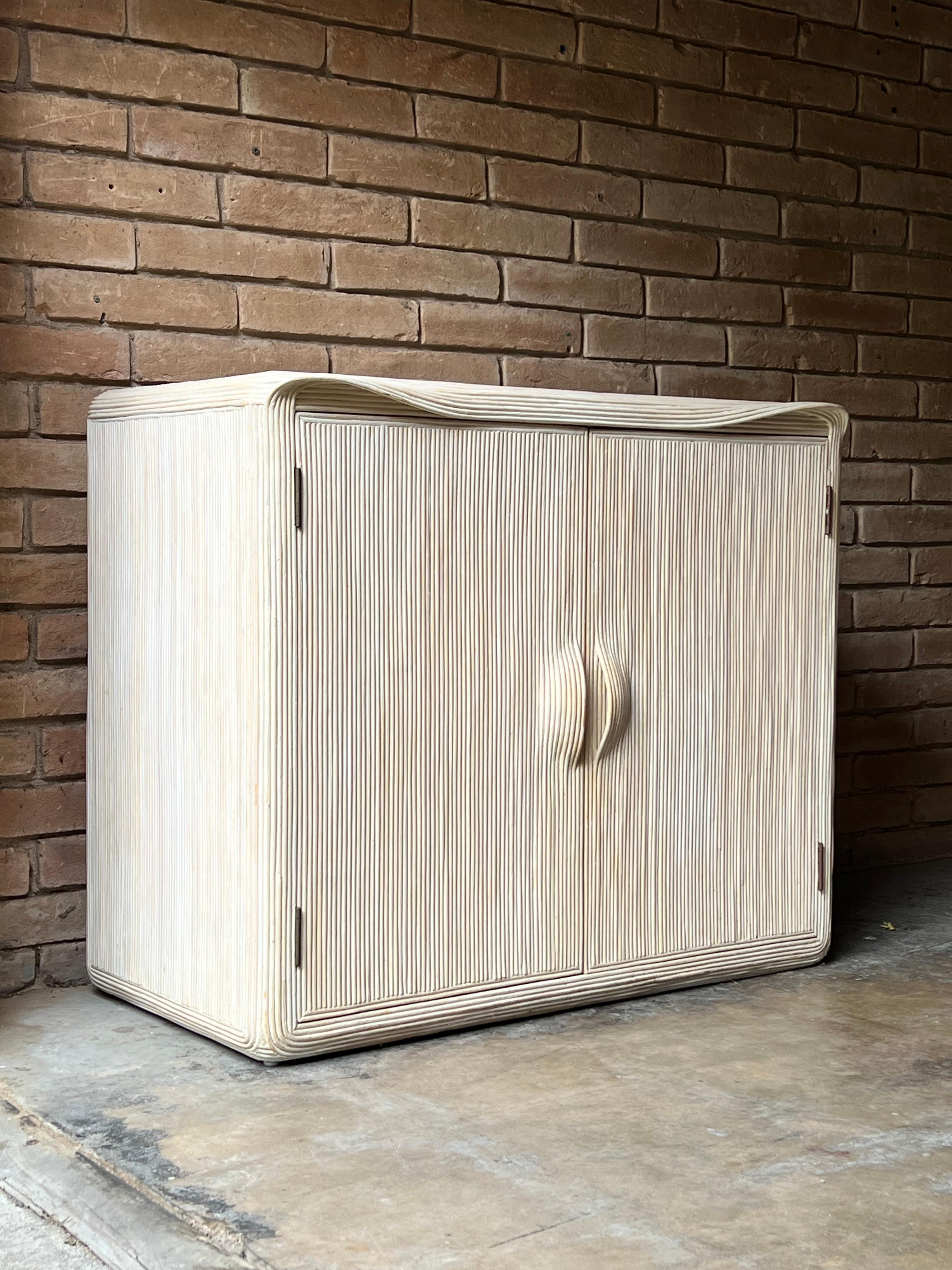 Beautiful and whimsical cabinet attributed to Betty Cobobpue. Made from a white washed reed, this functional yet sculptural piece features a single fixed interior shelf and offers ample deep storage. 

Can be used for linens, blankets or everyday