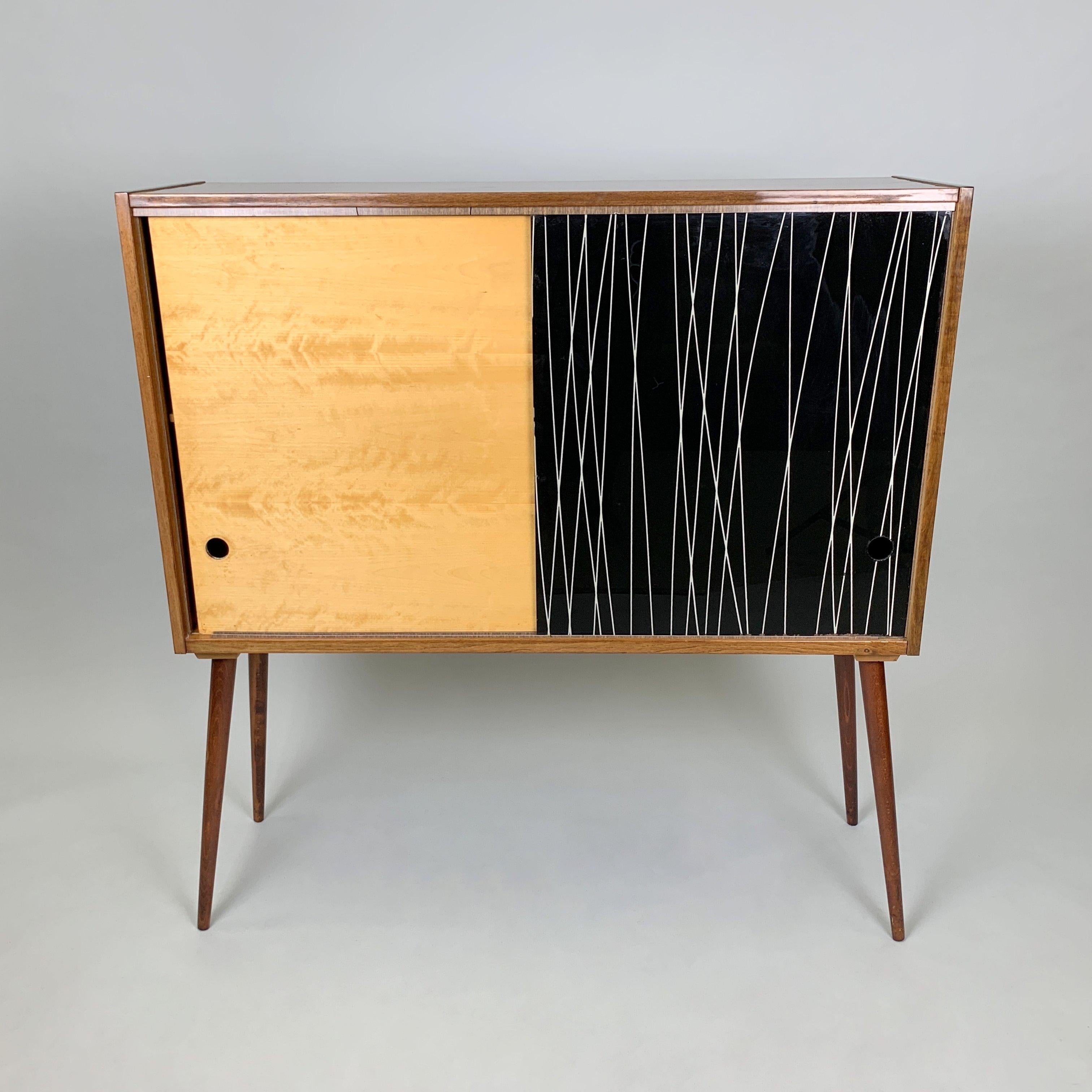 Vintage cabinet with sliding door, where one part is equipped with it't original mirror. Designed by Bohumil Landsman and Hubert Nepozitek for Jitona in former Czechoslovakia in the 1960s. Good original condition with some signs of use (see photo).