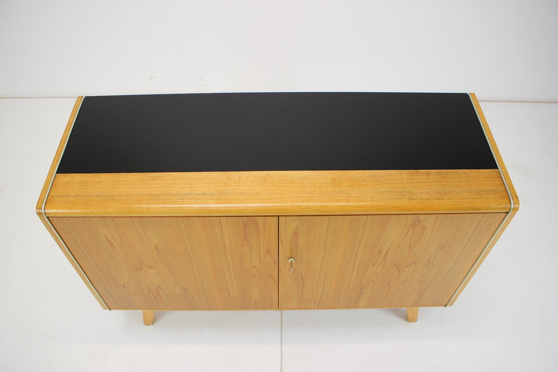 This mid century sideboard was designed by Hubert Nepožitek & Bohumil Landsman for Jitona company in the 1960´s. Material: Veneer wood, opaxite glass.
The glass has scratches on the surface.