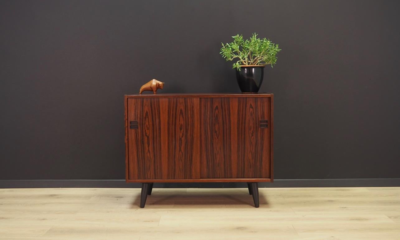 Classic cabinet from the 1960s-1970s. Danish design, Minimalist form. Surface of the furniture finished with rosewood veneer. Shelf behind a sliding door. Maintained in good condition (minor bruises and scratches) - directly to use.

Dimensions: