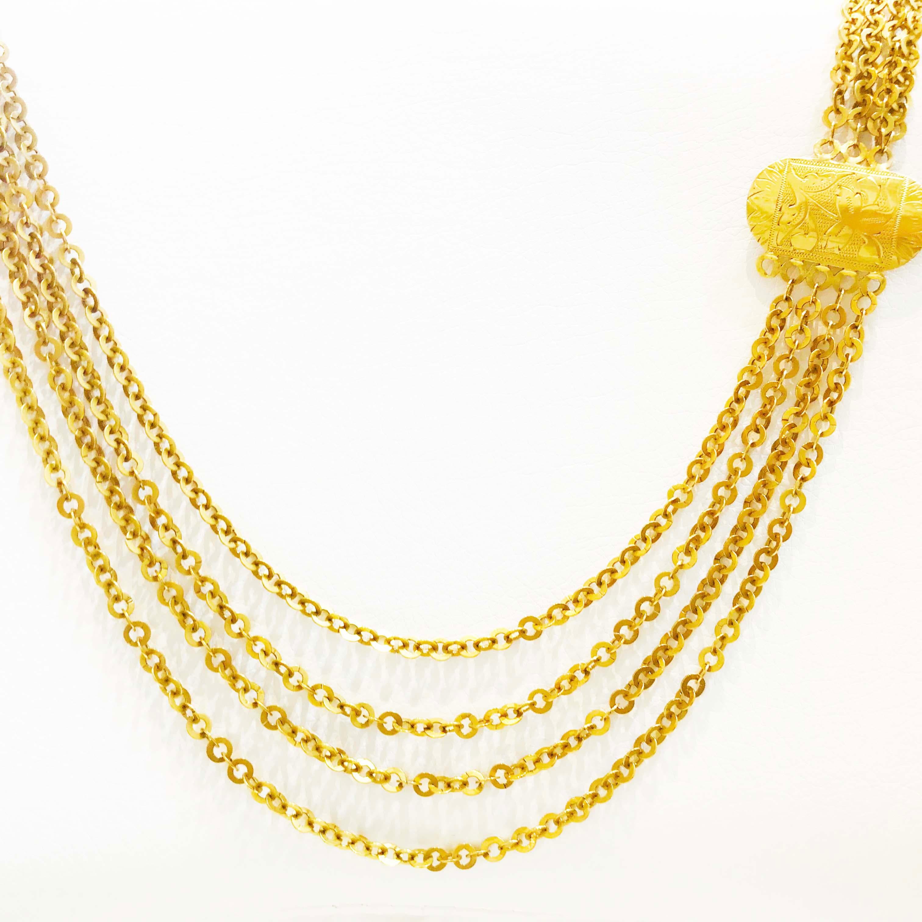 This gold necklace has four large link chains that Is thirty(30) inches long with an oval disk.  The oval disk is hand engraved and the entire necklace is quite striking!  The necklace is CIRCA 1920.  