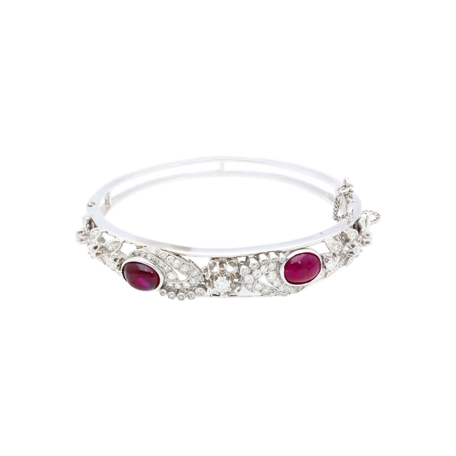 14 karat white gold mounts 2 vibrant cabochon cut red tourmaline gemstones, adorned by 81 round cut diamonds of over 2.50 carats. This bracelet features the quintessential Art Deco design, displaying stunning symmetrical patterns that complement the