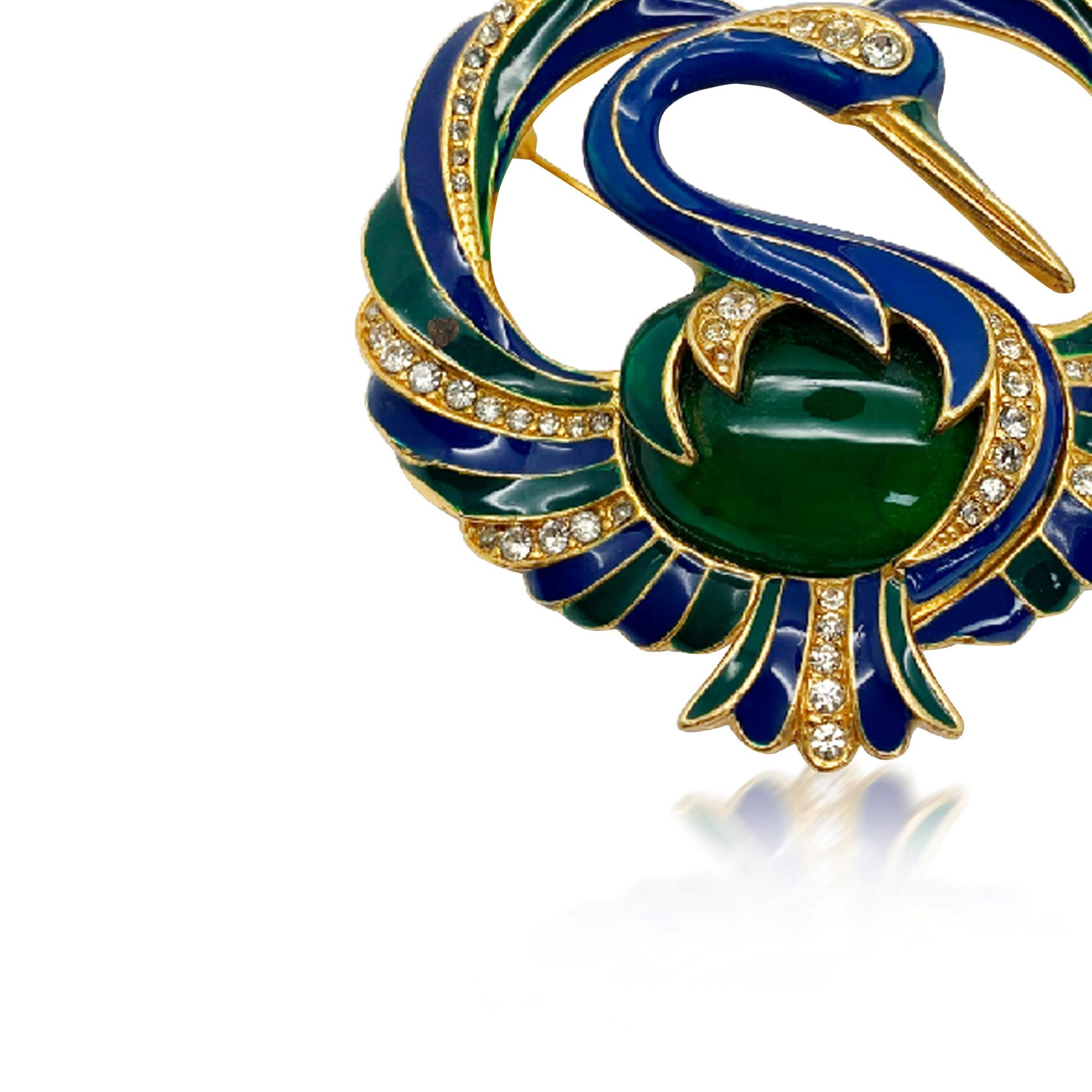 A Vintage cabochon bird brooch. Featuring sumptuous green and blue enamel detailing and a large oval cabochon stone for the belly. 
Vintage Condition: Very good without damage or noteworthy wear. 
Materials: Gold plated metal, glass, enamel
Signed: