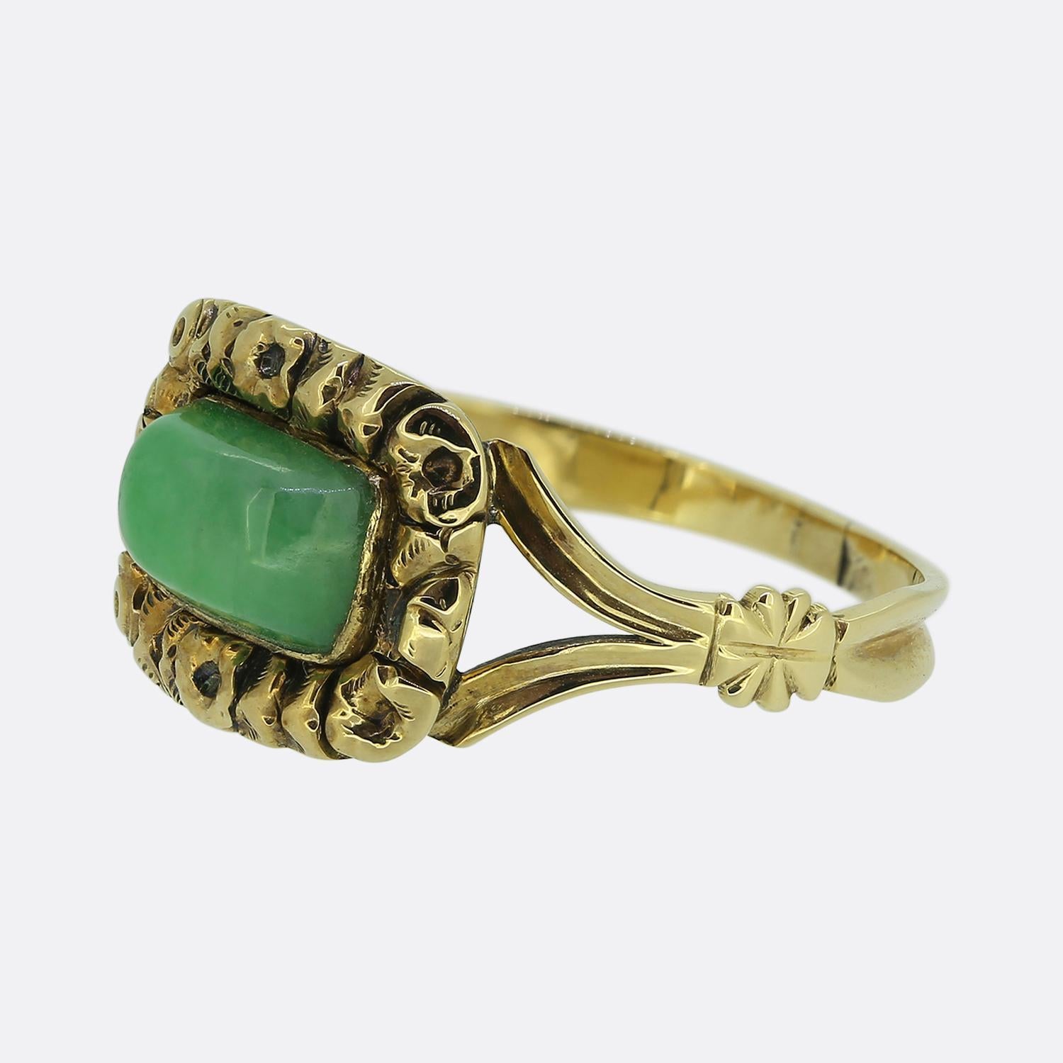 Hier haben wir einen bezaubernden Ring mit einem einzigen Stein. Dieses Vintage-Stück wurde aus 18-karätigem Gelbgold gefertigt und zeigt einen einzelnen Cabochon-Jade-Edelstein in der Mitte des Gesichts inmitten eines wunderschön handgeschnitzten