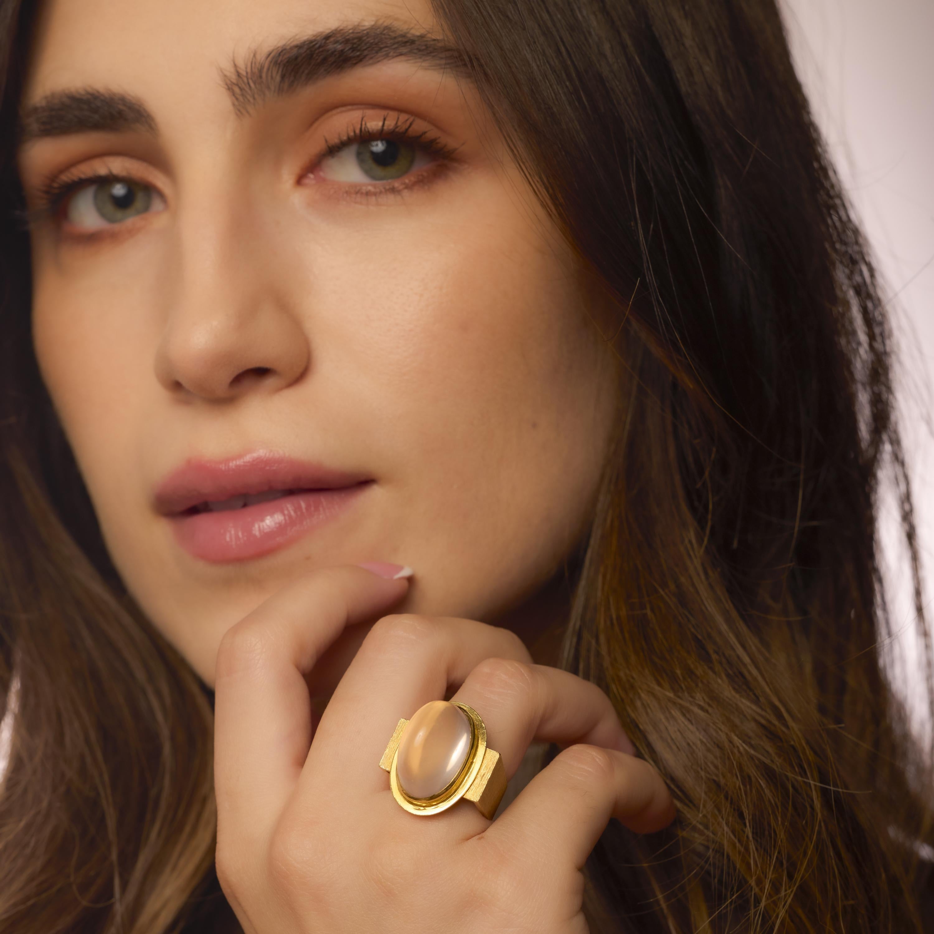 A sculptural 1970s French ring set with a luminous pink quartz cabochon in gleaming 18k yellow gold, embodying vintage elegance and bold design.