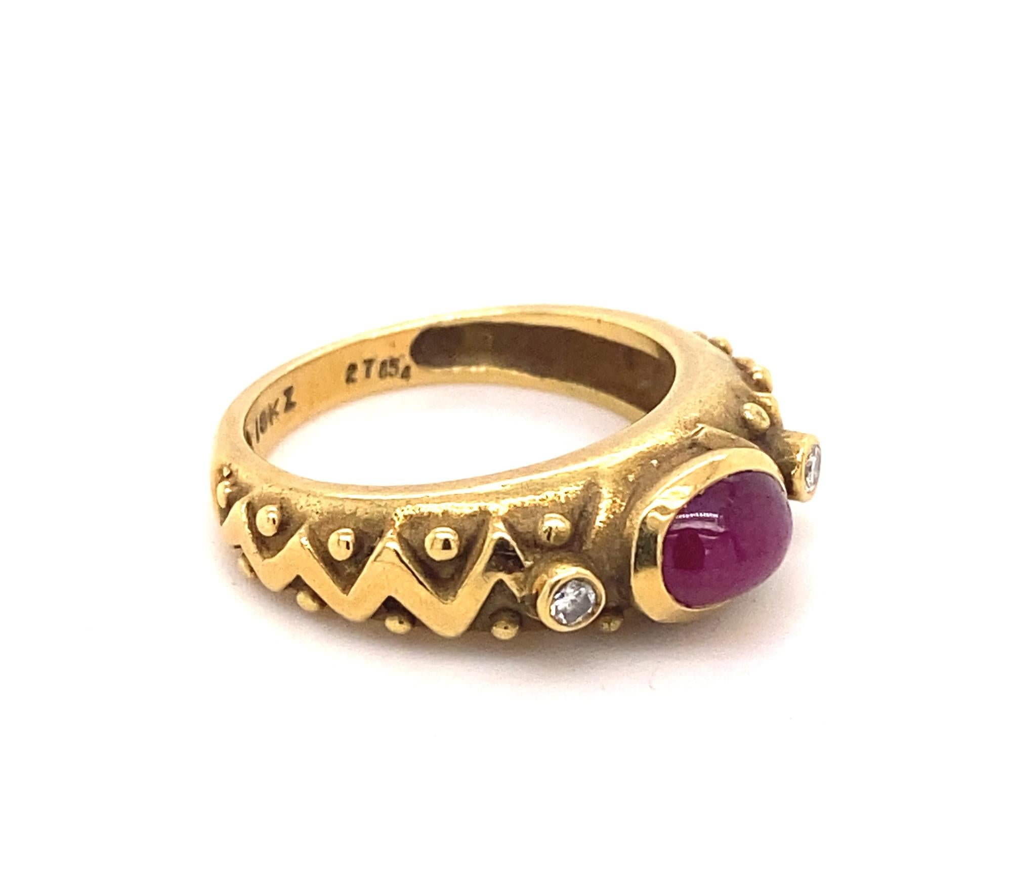 This is a beautiful vintage 18k yellow gold ring with a natural cabochon ruby and two diamonds.  The ring has a unique zig zag pattern on the shank.  The cabochon ruby has nice deep red color and good clarity. Two diamonds are I color VS-2 clarity