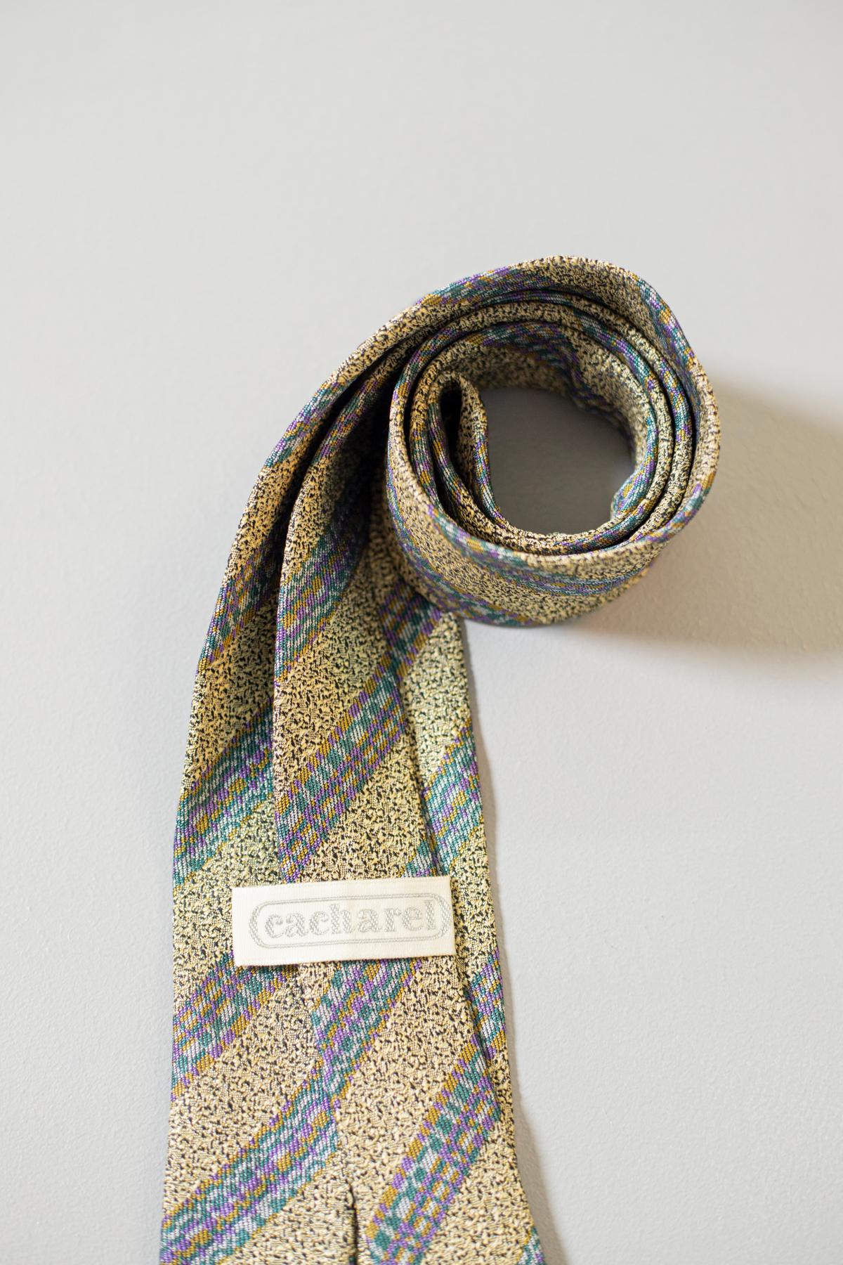 Diese Krawatte ist mit blauen, rosa, grünen und gelben Jacquard-Streifen auf schwarzem und goldenem Hintergrund verziert und peppt Ihr Outfit auf. Das in Frankreich hergestellte und von Cacharel gestaltete Modell ist das ideale Accessoire, wenn Sie