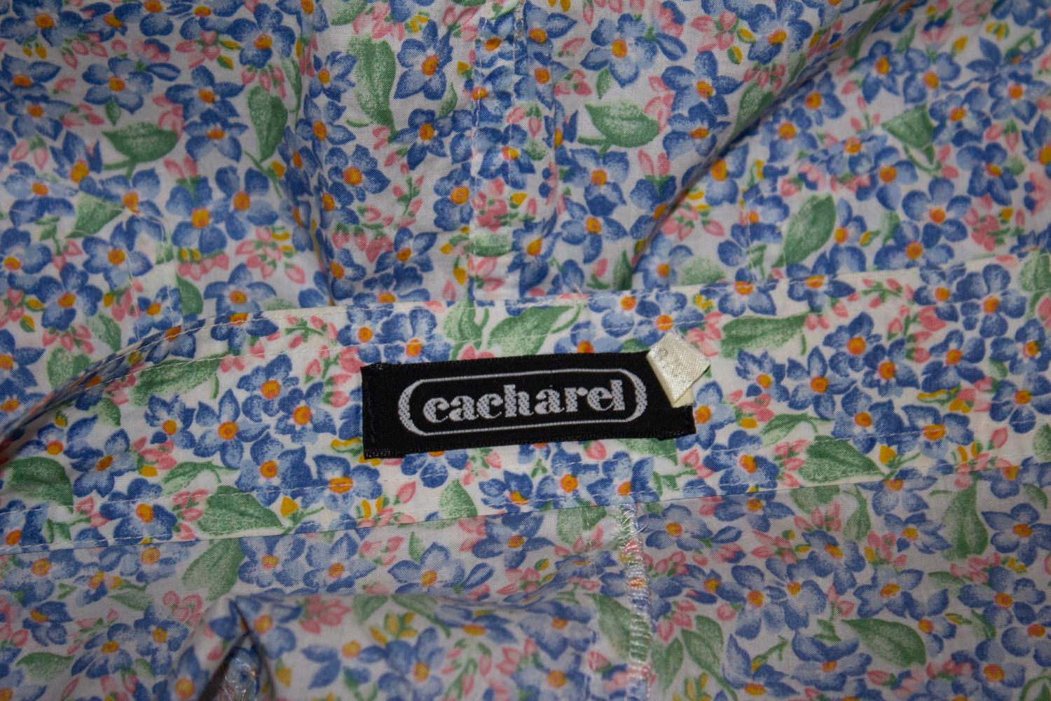 A pretty vintage cotton skirt by French brand Cacharel. In a pretty print of blue , green and pink florals, the skirt has a button front opening, belt hoops, and pockets on the front and back. It is unlined. 
Measurements: Waist 28'', length 20''