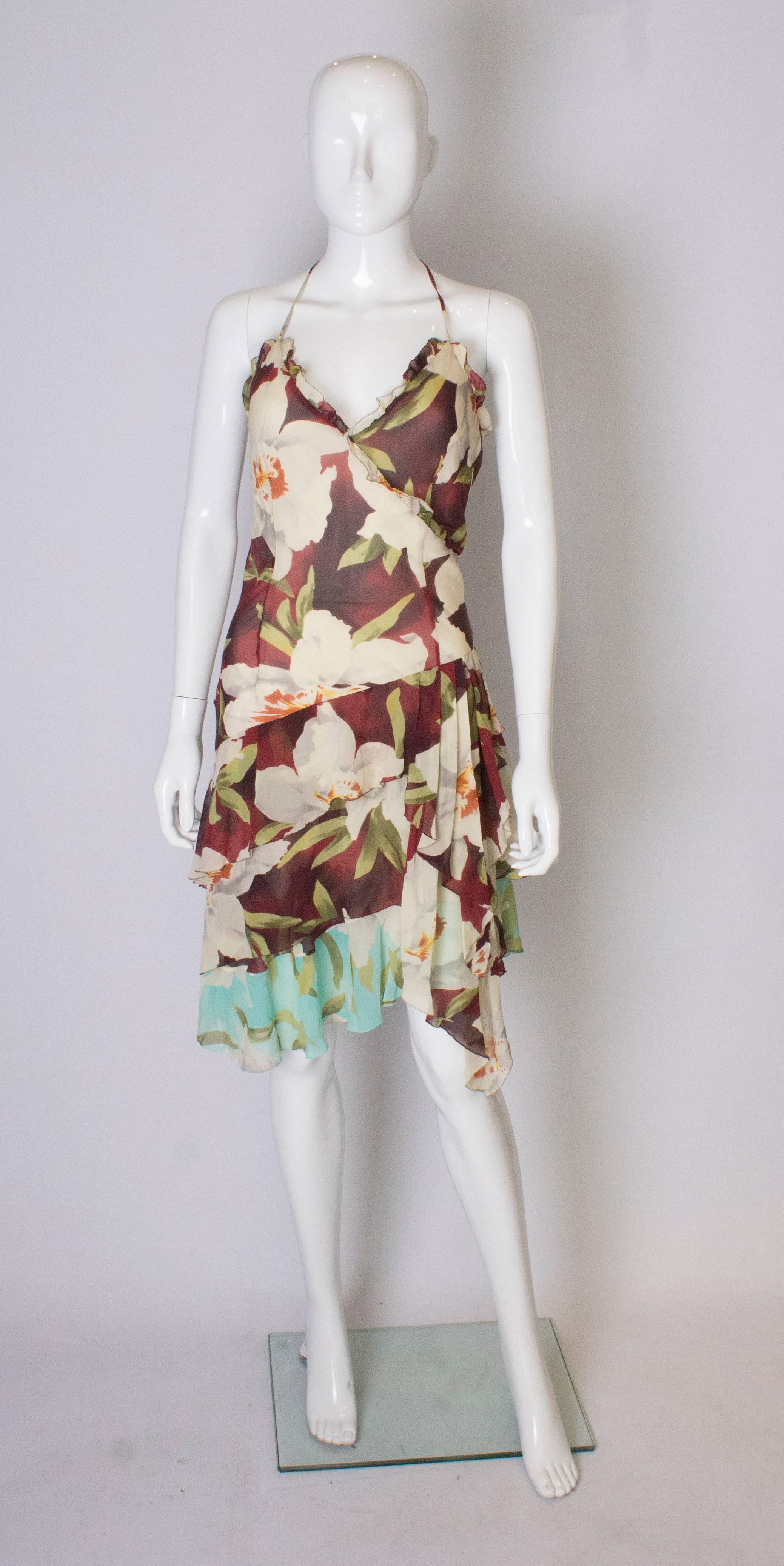 A 1990's pretty, floaty , floral silk dress by Cacharel. The dress is in a floral print with layers of silk,   and has spagetti straps and a hankerchief hem.  It has a side zip and is fully lined.