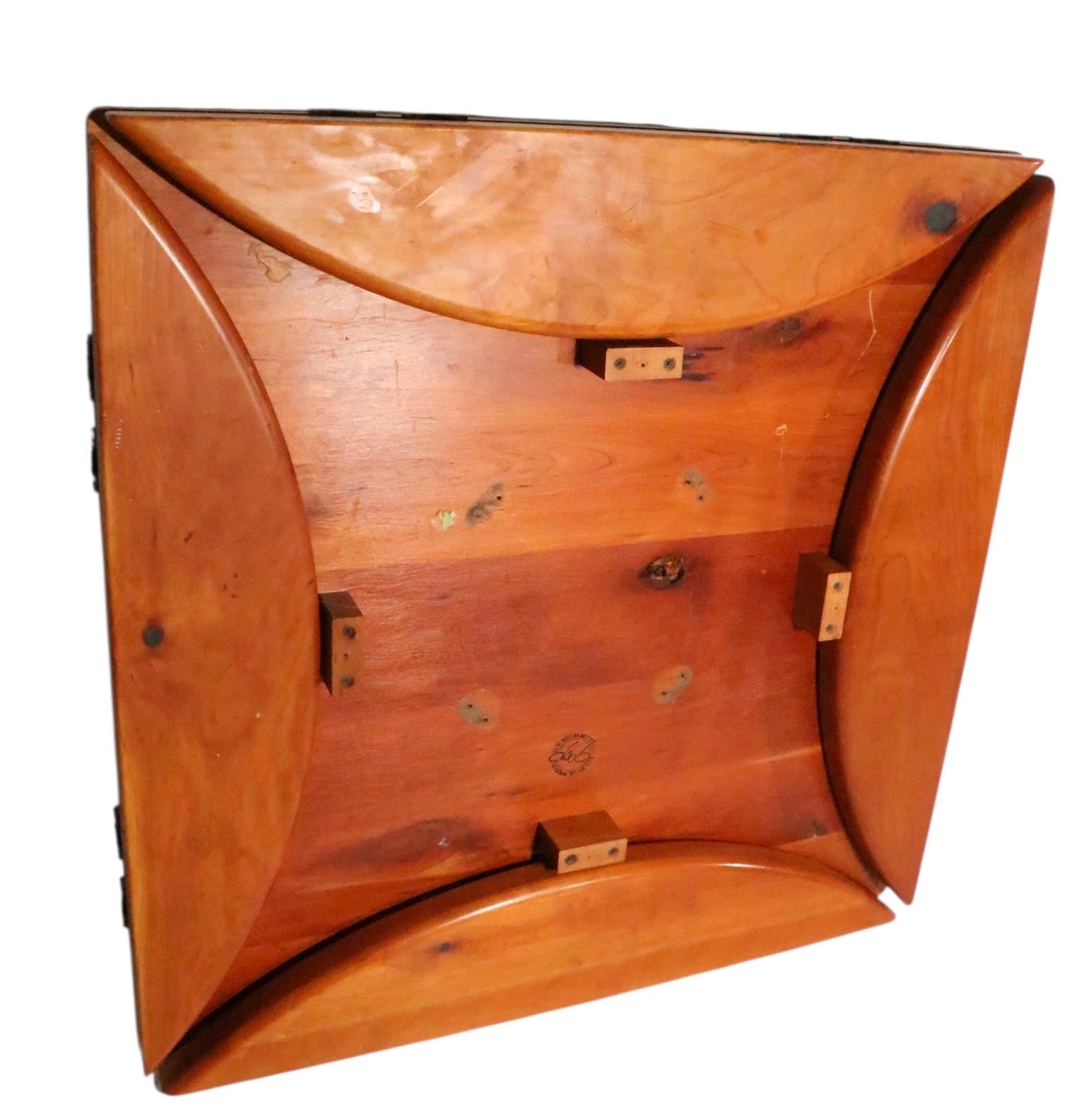 Well crafted cafe, bistro style dining table, having a thick wood top with four drop leaves, mounted on a footed iron base. 
  The top is square  ( 36