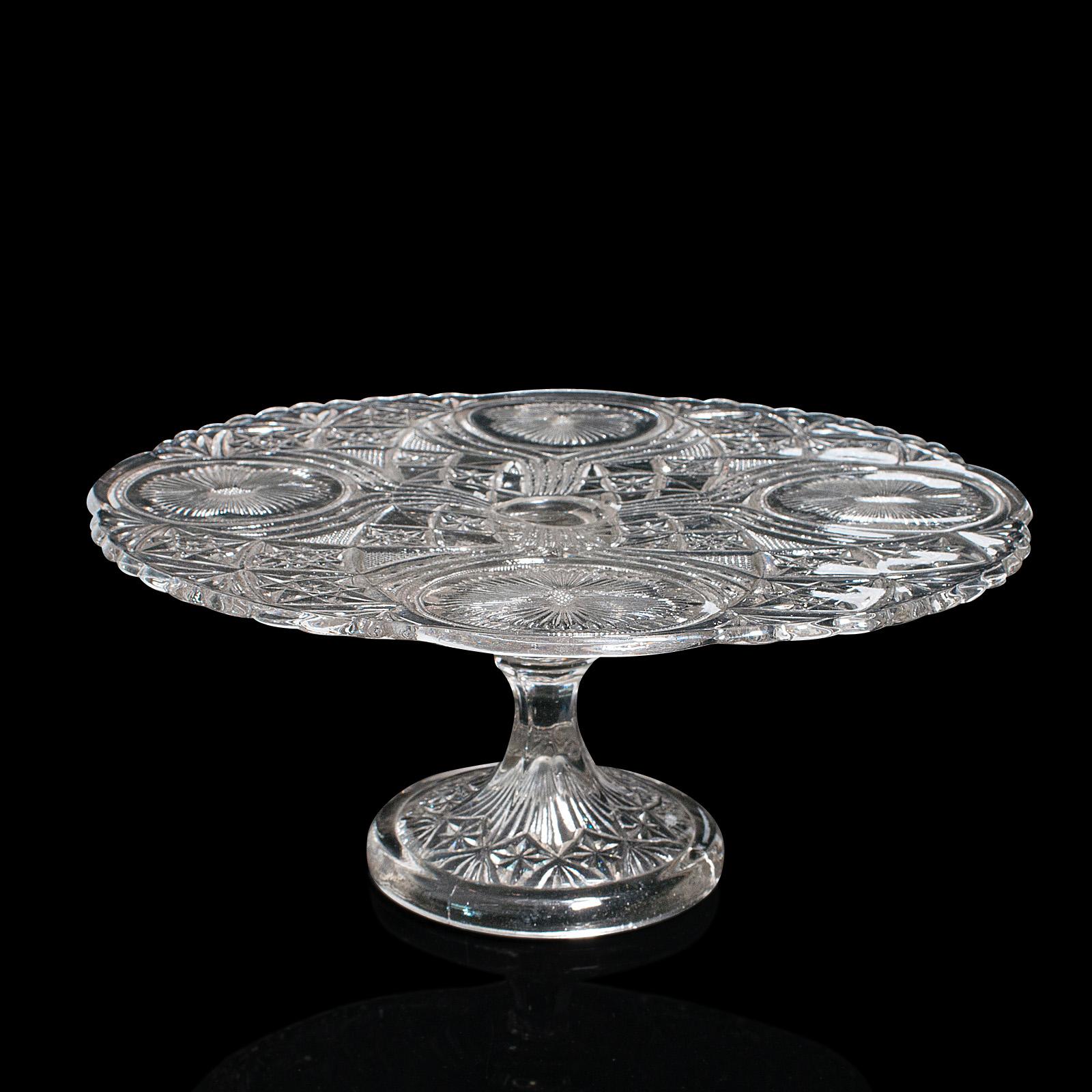 This is a vintage cake stand. A French, glass afternoon tea serving platter, dating to the mid 20th century, circa 1950.

Enthusiastically decorated glass presents a quality appeal
Displaying a desirable aged patina and in good order
Cut glass