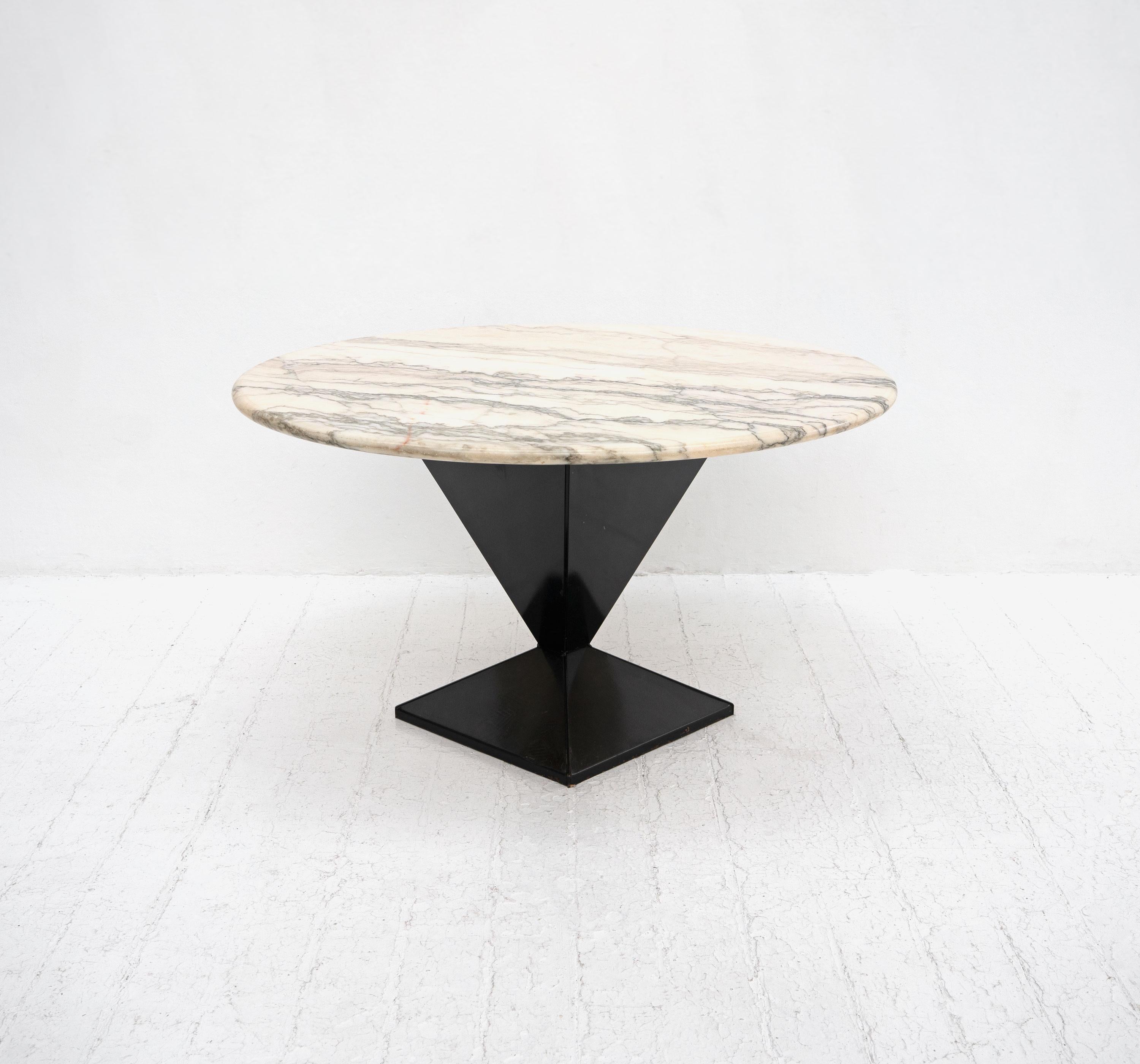A mid-late 20th Century dining table composed from a prismatic lacquered metal base supporting a circular Calacatta marble top with grey and amber veins.

Dimensions (cm, approx):
Height: 73
Diameter: 130

Condition: The marble is in very good