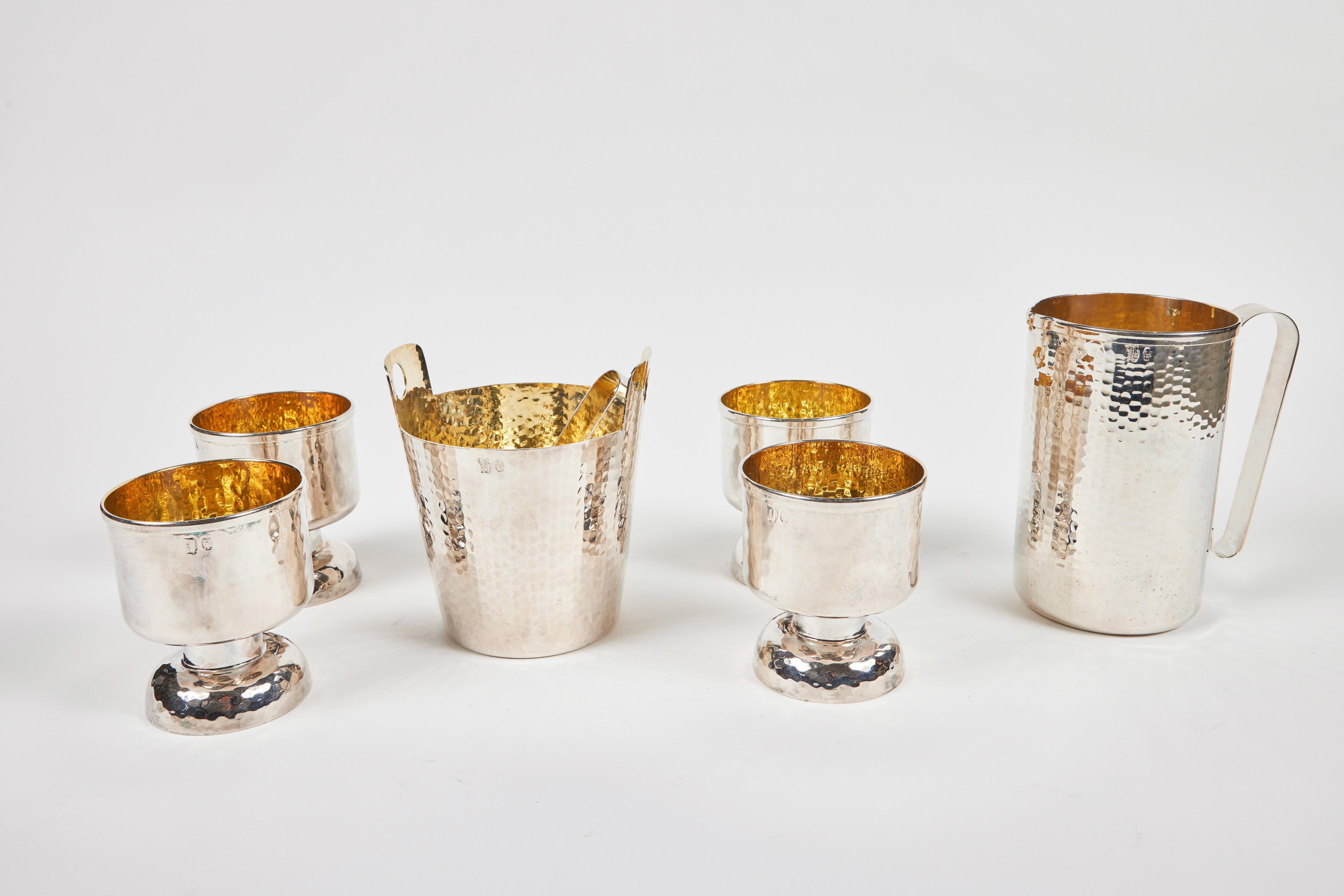 Nothing dazzles more than this gorgeous vintage Calegaro hammered silverplate bar set with rich gold wash interior accent:
It includes 4 ample cups, 1 stout pitcher and a beautiful ice bucket with handles and matching silver tongs. They are Hallmark