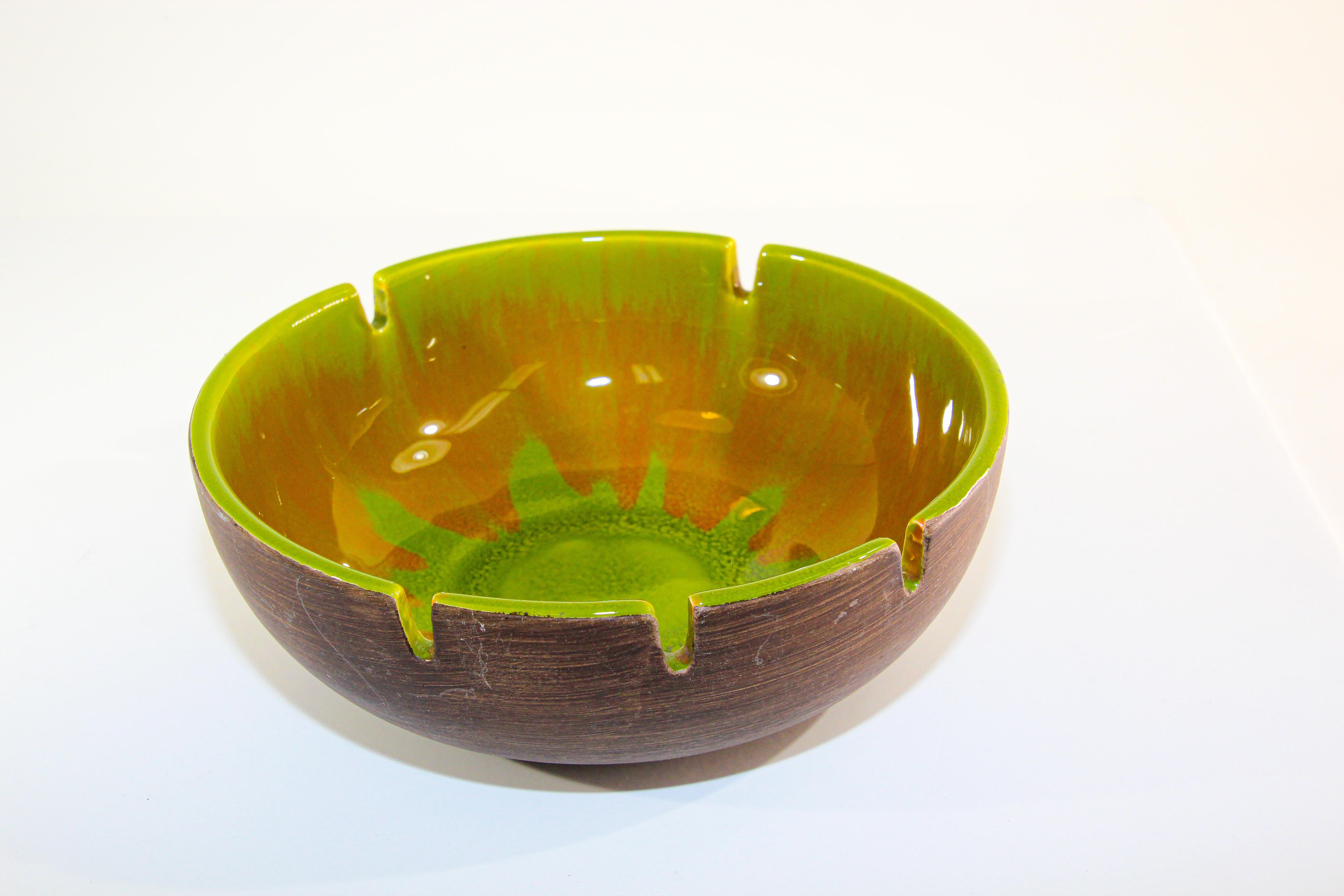 Gorgeous vintage ashtray with a glowing splash in yellow, green and brown colors.
Classic Mid-Century Modern round ashtray in yellow green and brown glazed ceramic, the outside is painted brown but not glazed.
The ceramic tray is in good