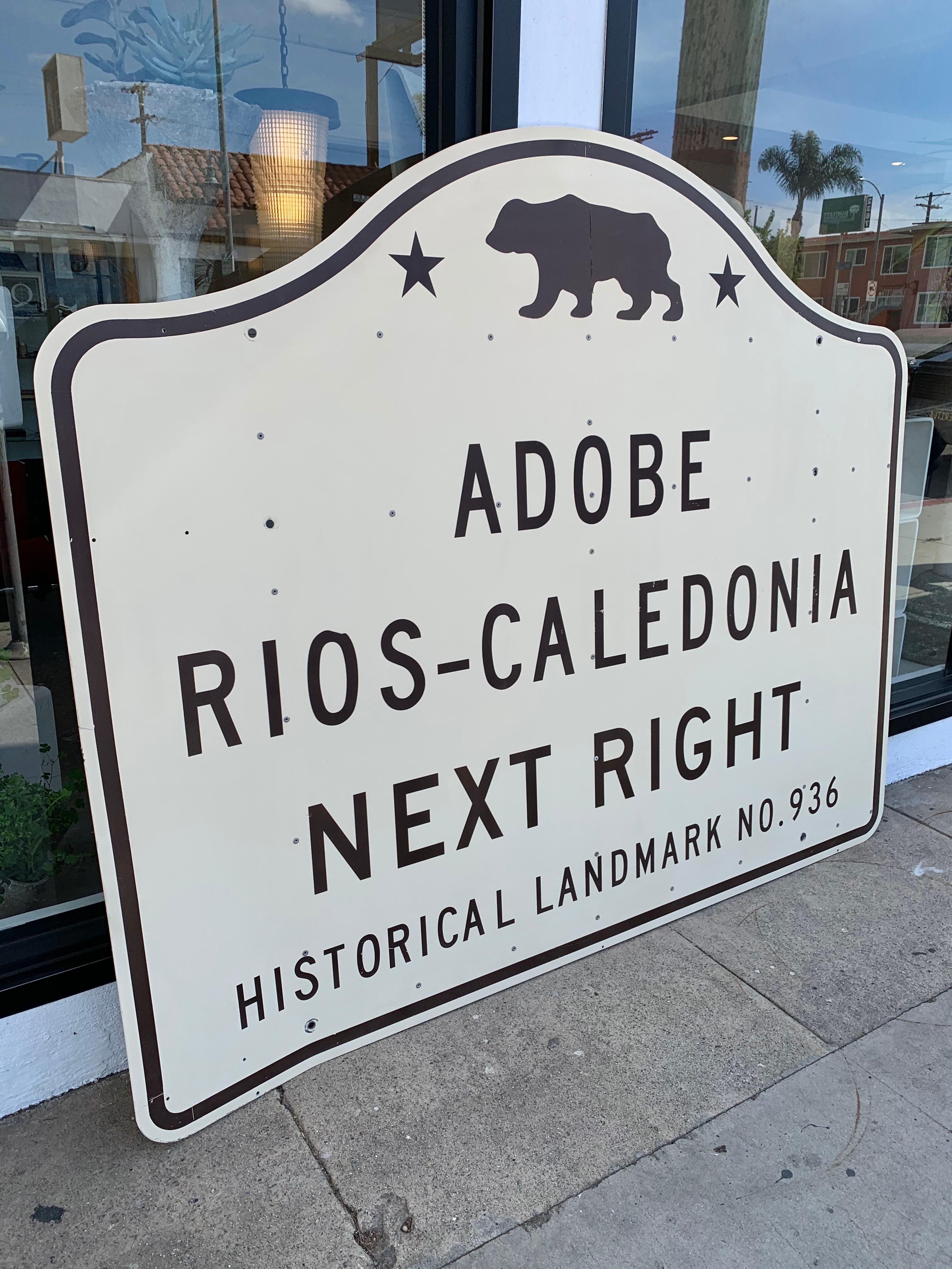 Interessantes altes kalifornisches Highway-Schild für Adobe Rios-Caledonia. Das Gebäude ist ein historisches Wahrzeichen Kaliforniens und steht im National Register of Historic Places. Es ist ein 1835 erbautes Lehmziegelhaus in San Miguel,
