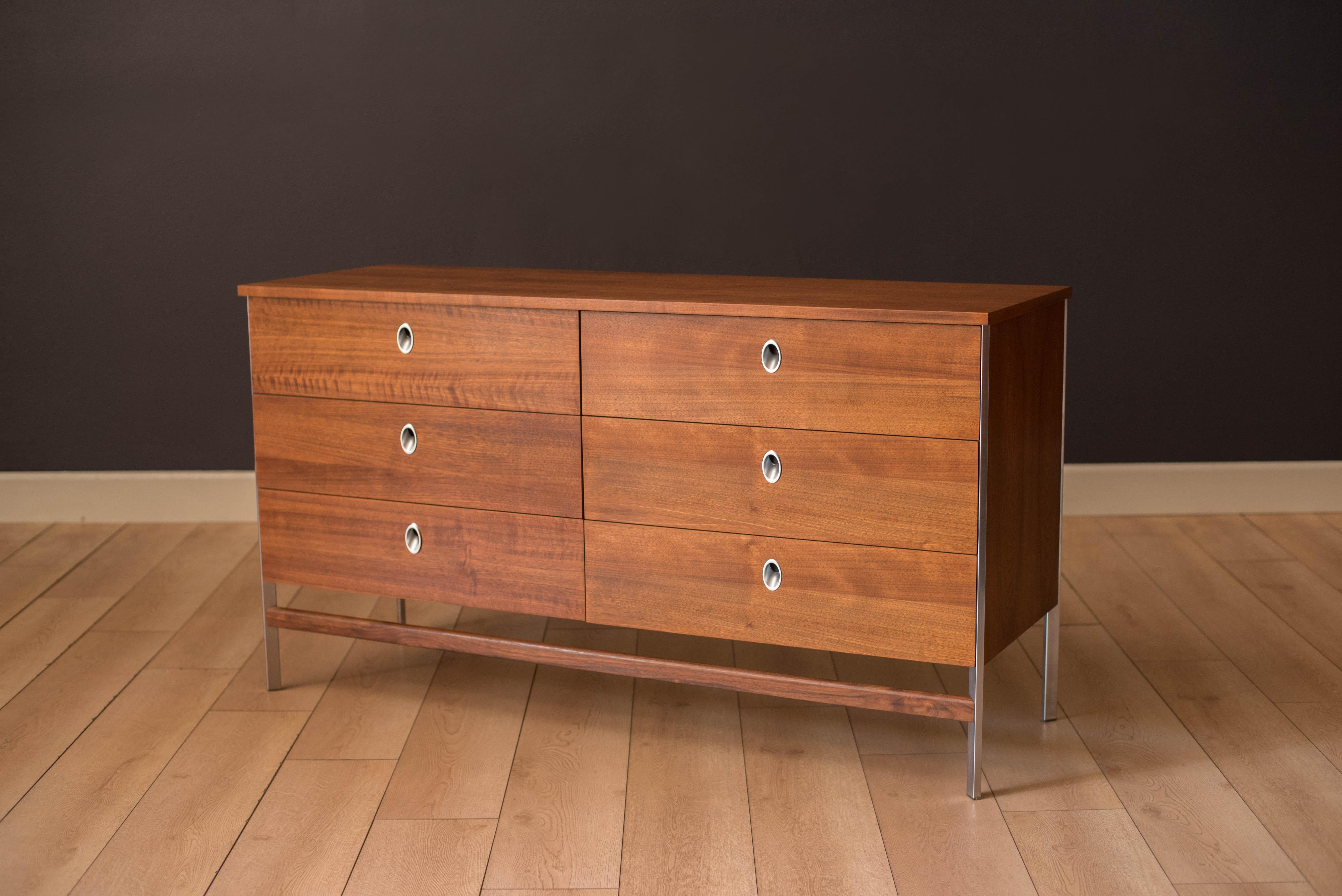 Mid-Century Modern dresser in walnut manufactured by Vista of California circa 1960's. This piece features six storage drawers with unique polished aluminum pulls. Supported by an angular steel frame base finished with a floating walnut crossbar.