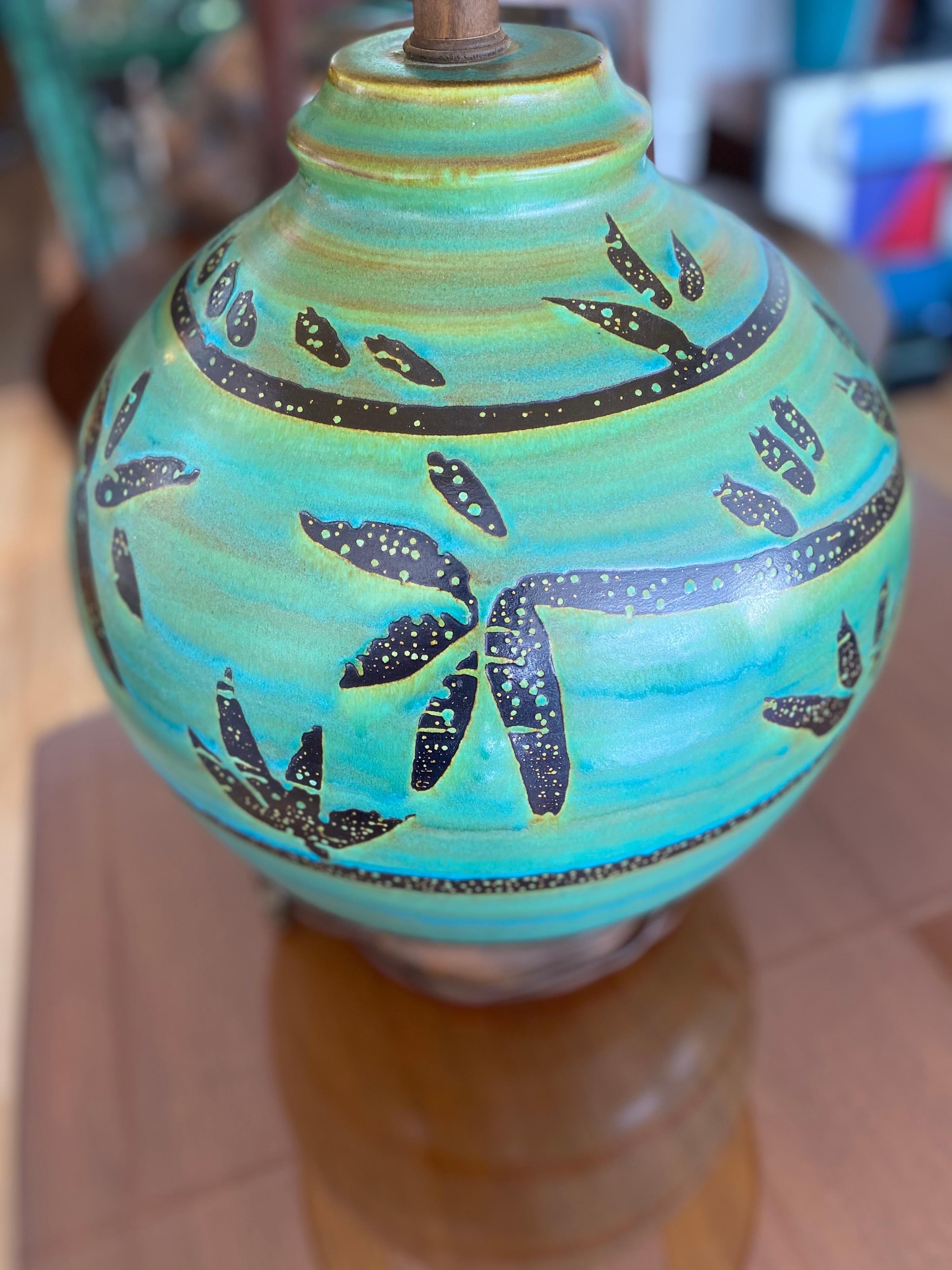 Beautiful large vintage California pottery table lamp. This lamp has a floral motif with varying shades of turquoise and yellowish-brown hues mixed within. This table lamp is in great condition.
 