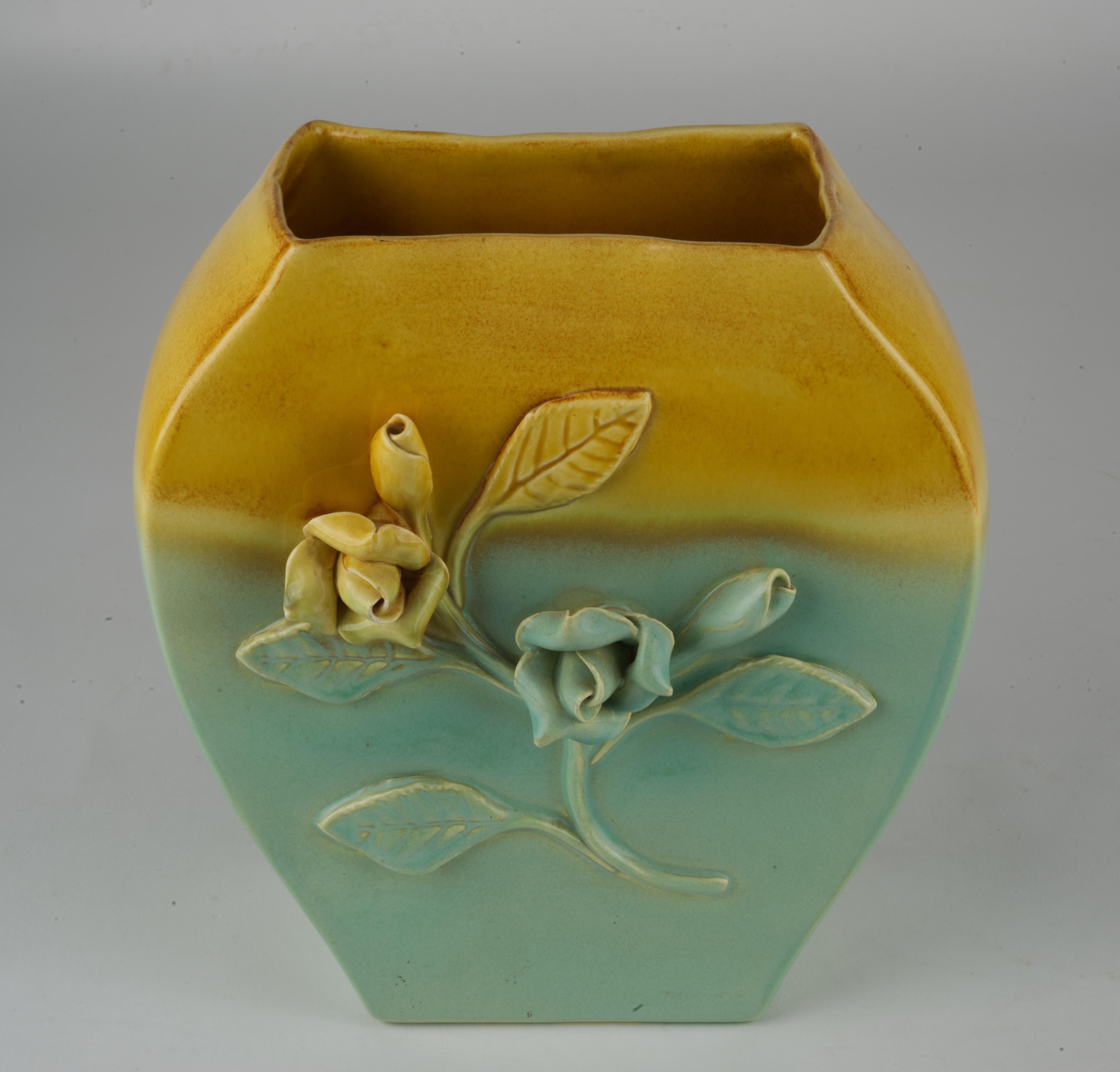  Ce vase vintage en poterie californienne est décoré de fleurs appliquées ; il est émaillé d'une combinaison de glaçure jaune brillante sur le dessus et de glaçure bleu clair semi-mate sur le reste du vase. Il est signé sur le fond avec un numéro de
