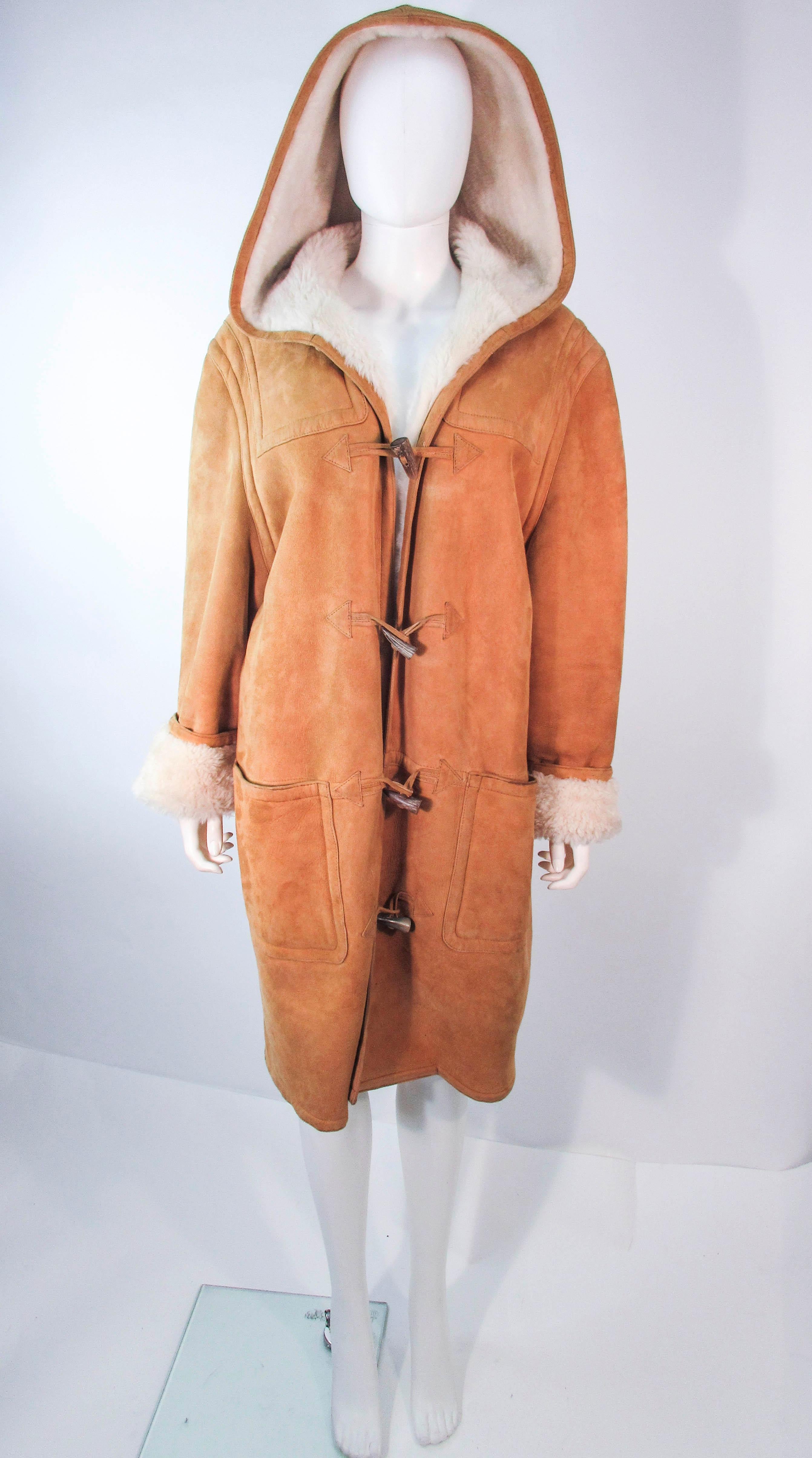 This is a fabulous vintage Calvin Klein design which is composed out a beautiful brown shearling with a large hood. This piece is absolutely perfect for winter. There are front pockets and toggle closures. In great vintage condition, sold 