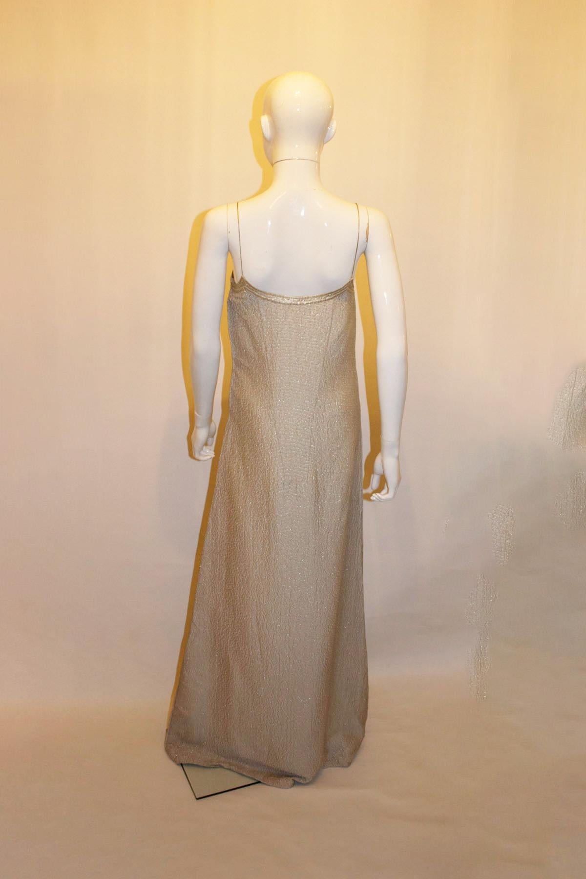 Une superbe robe de soirée vintage en argent de Calvin Klein. La robe est en soie et argent.  Il est composé d'un mélange de tissus texturés, de bretelles spaghetti et d'une ouverture zippée sur le côté.  à gauche.  Fabriquées en Italie.
Taille 4 .