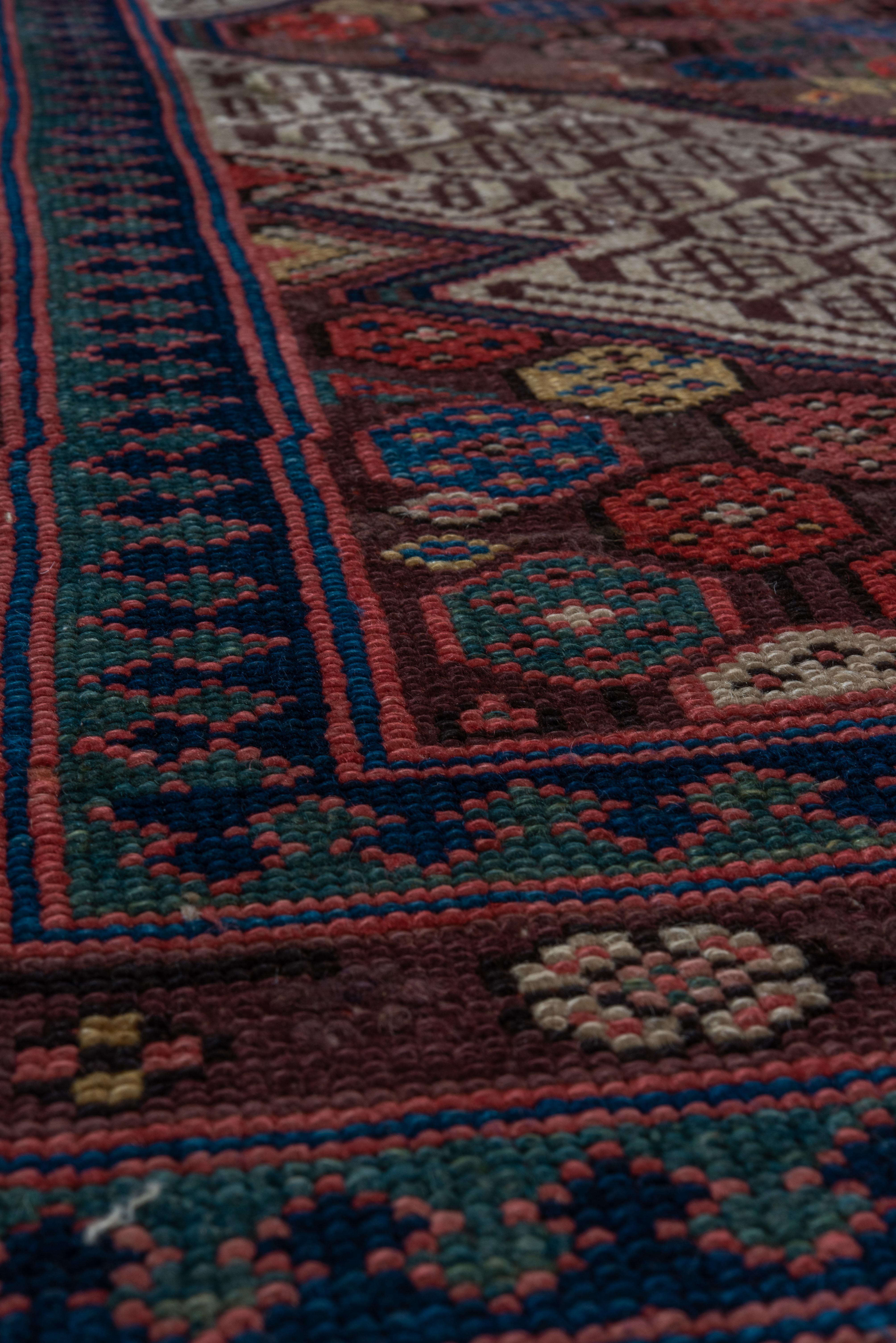 This vintage Cam Hamadan runner showcases a striking sequence of stepped medallions, each filled with tightly spaced octagonal floral motifs. The interplay of soft beige, earthy reds, and pops of saffron and indigo add a vibrant rhythm throughout