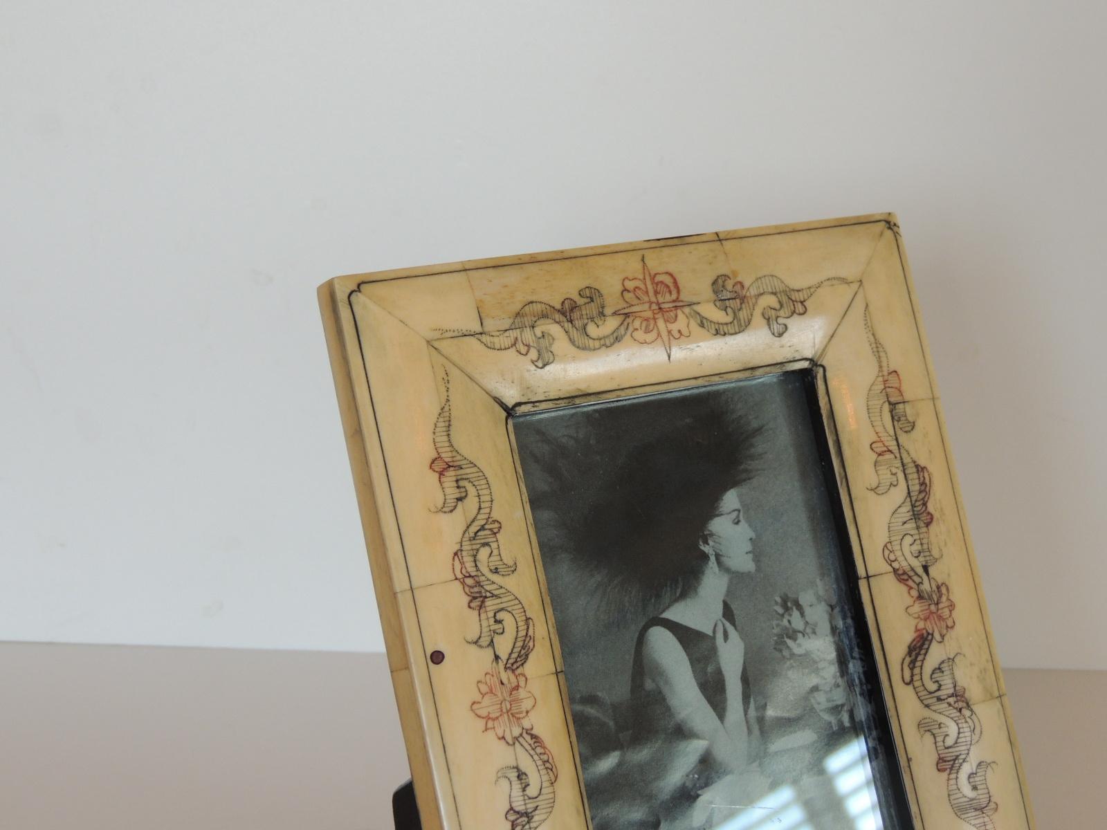 Vintage Camel Bone Picture Frame with Carved Design In The Front.
Black lacquered wood back.
Size: 5.3/4