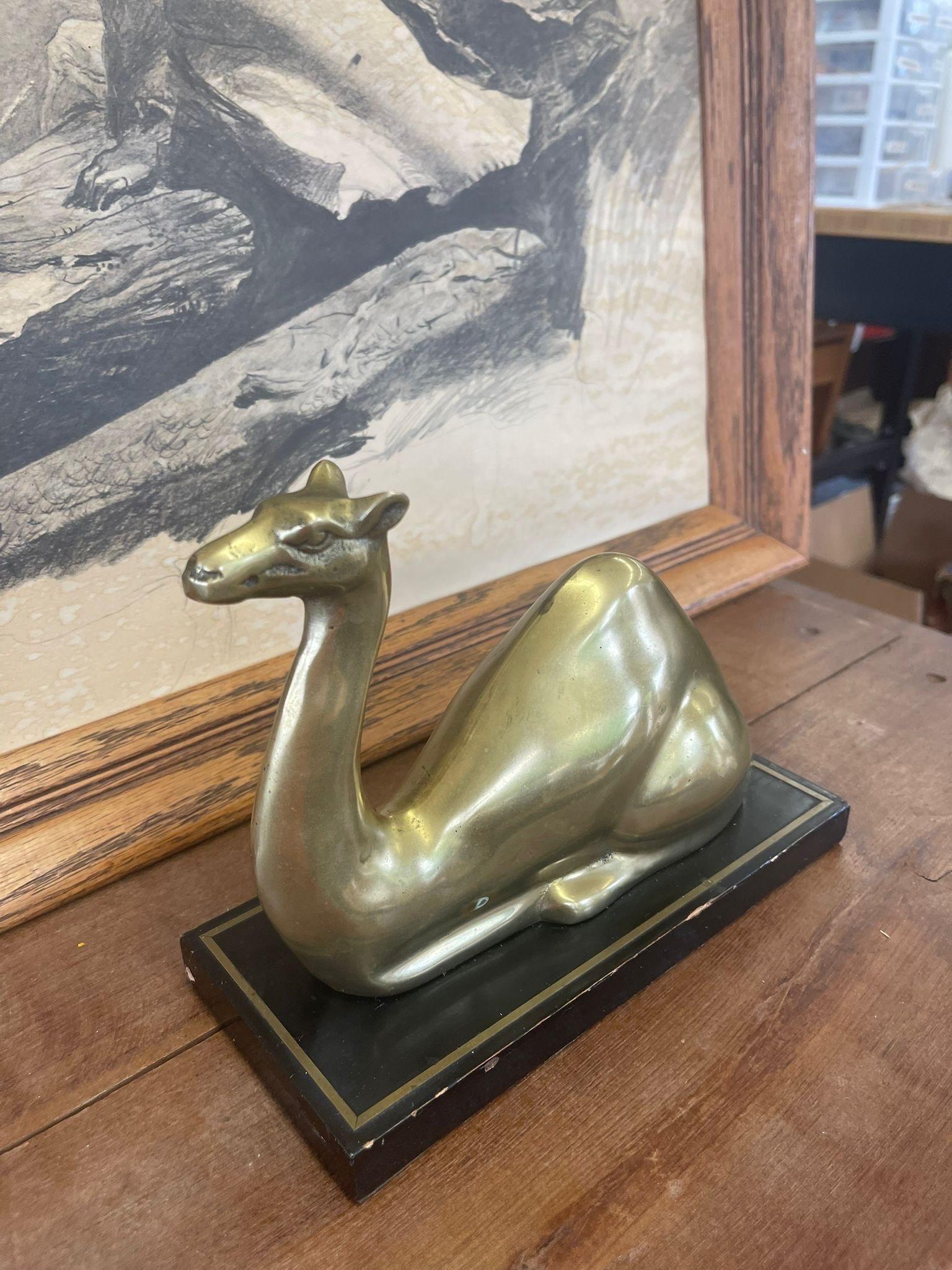 Camel Figurine on a Wooden Base. Possibly Brass, Slight Petina on a Gold Tone. Vintage Condition Consistent with Age.

Dimensions. 9 W ; 4 D ; 7 H
